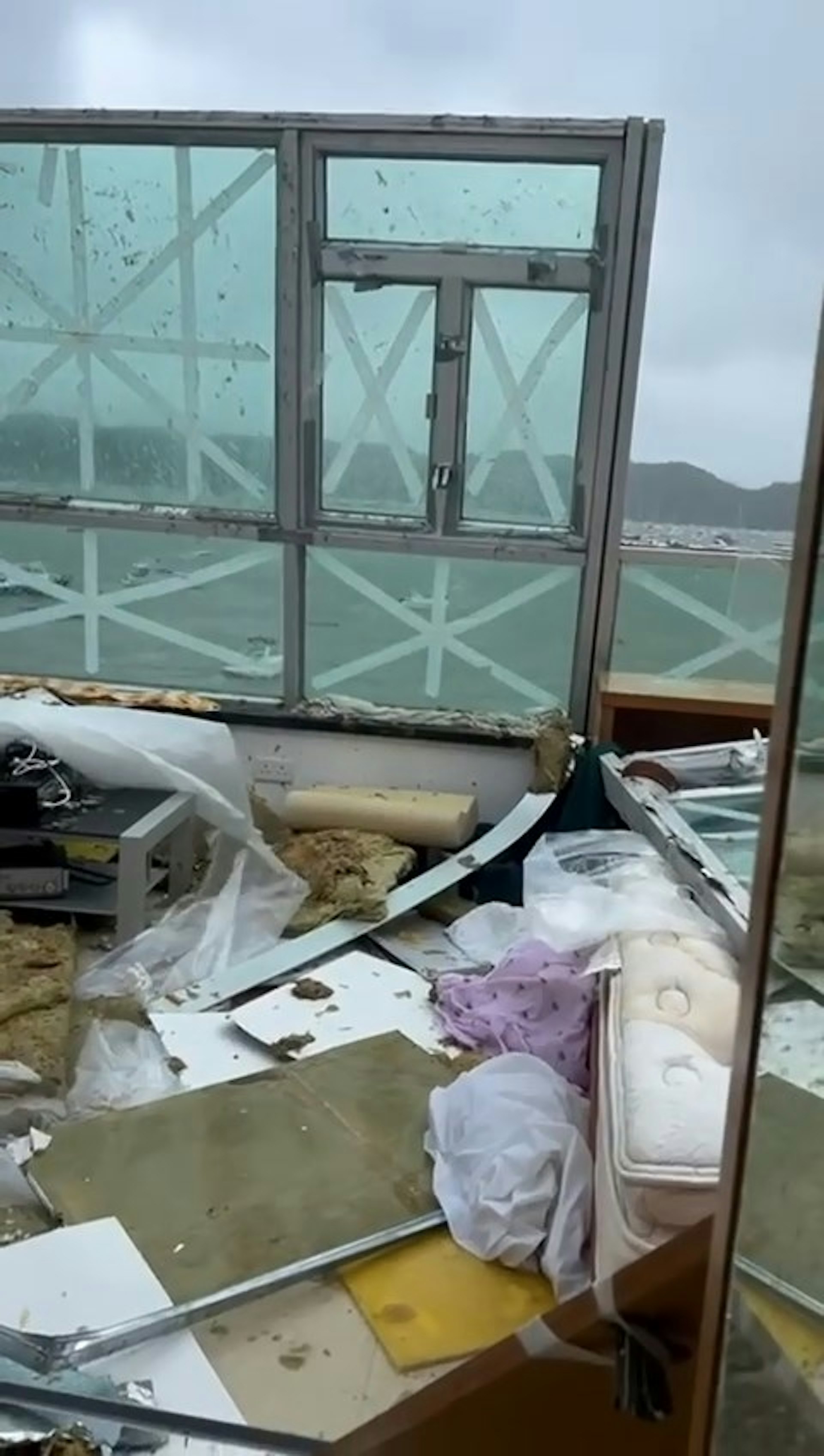 該海景單位屋頂「消失」,疑似被吹走,單位內堆滿電腦、木板、布條等雜物,床也被「淹沒」。(Threads@kaitakbigbelly) 該海景單位屋頂「消失」,疑似被吹走,單位內堆滿電腦、木板、布條等雜物,床也被「淹沒」。(Threads@kaitakbigbelly)