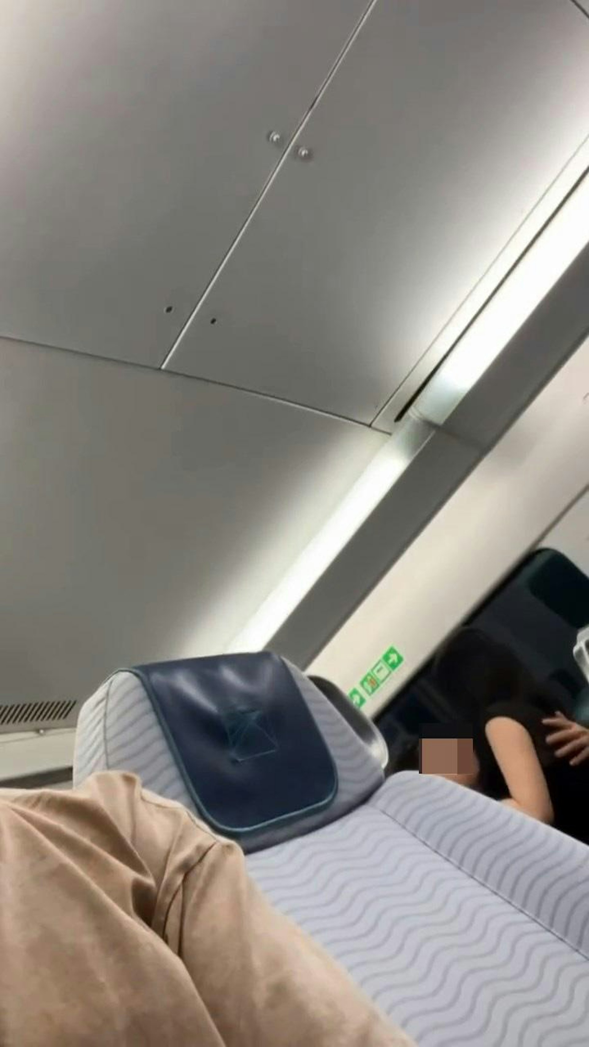 港鐵機場快綫列車座位上,有1名長髮、穿透視露膊裝女子,騎在1名戴眼鏡男子上面激烈擁吻。(Threads@paddyjai_)