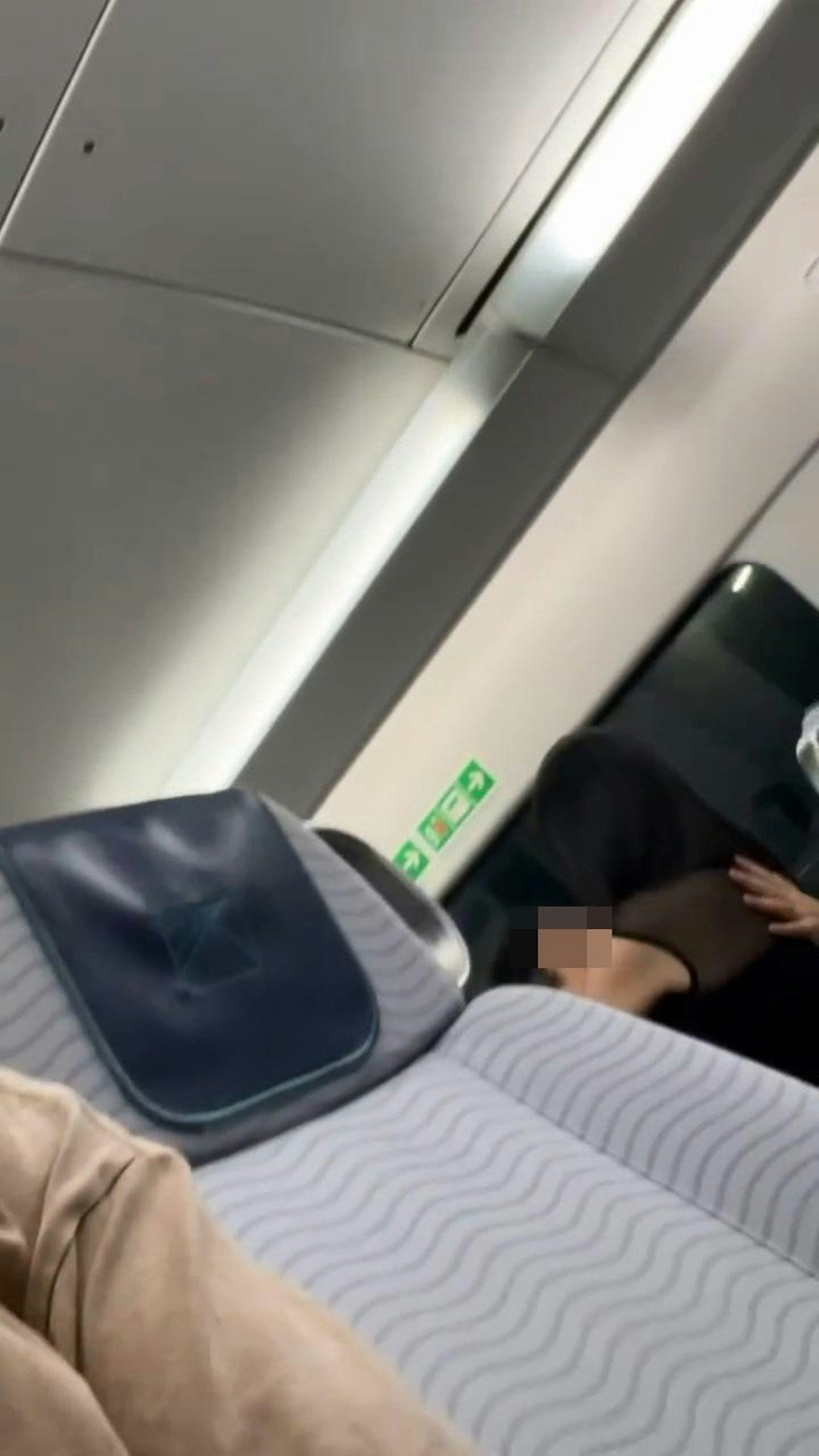 港鐵機場快綫列車座位上,有1名長髮、穿透視露膊裝女子,騎在1名戴眼鏡男子上面激烈擁吻。(Threads@paddyjai_)