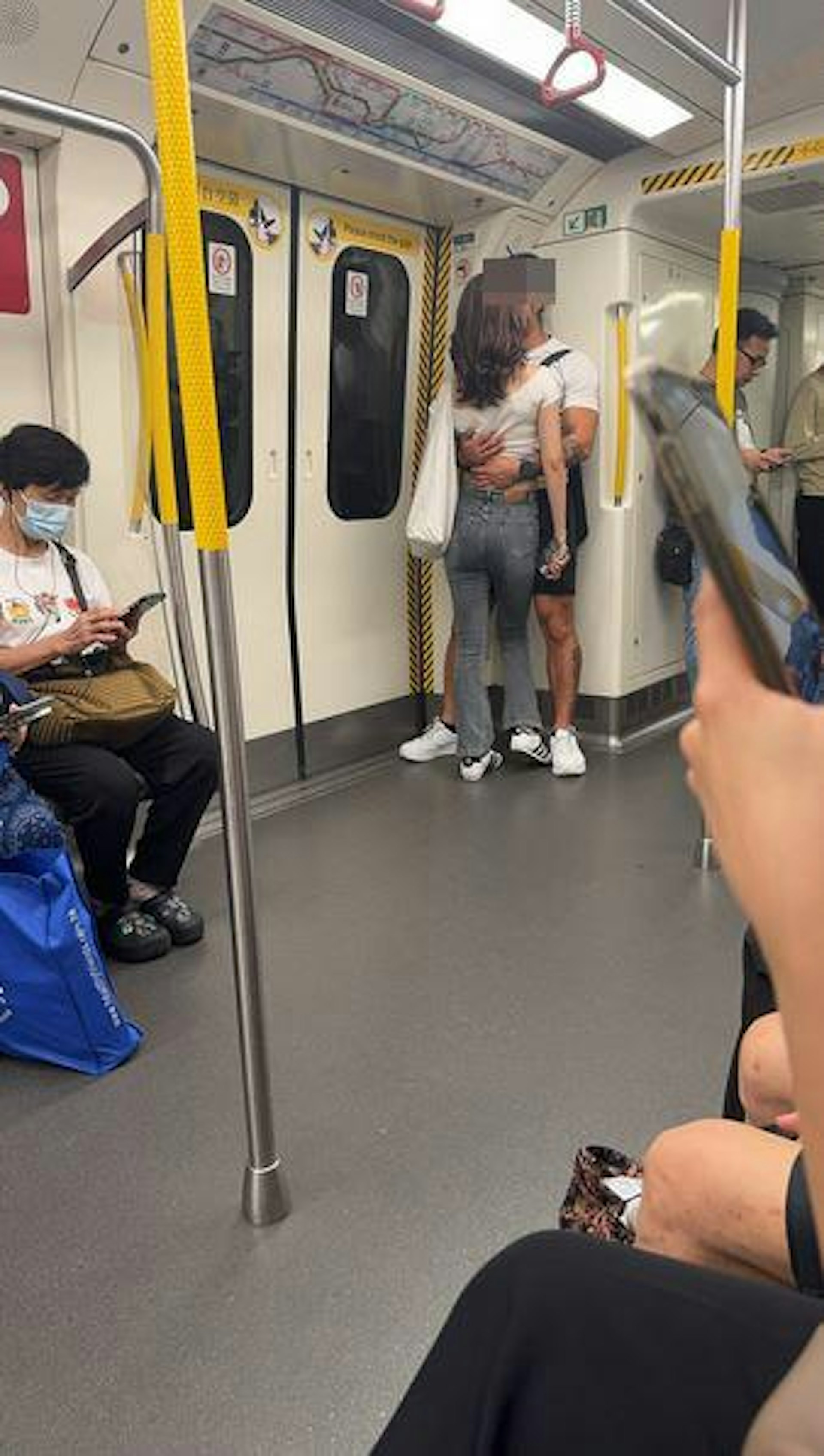 這對男女靠近車廂連接卡旁門邊位置,疑似正在激吻,其中男方雙手把女方緊緊抱着。(Threads@lyl_____0819)