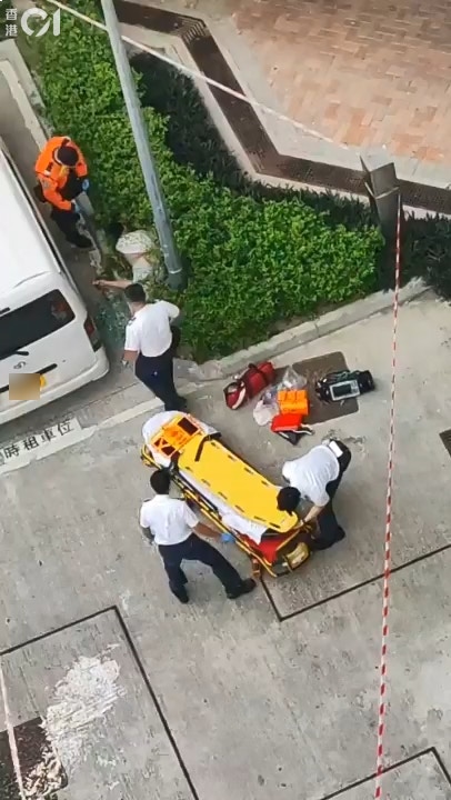 屯門菁田邨男童墮樓倒臥花槽，救護員接報到場施救。（讀者提供）