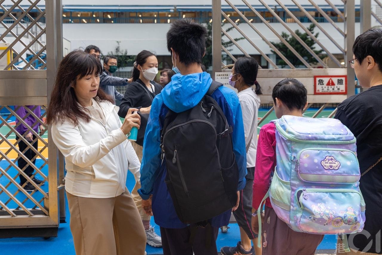 鑽石山鳳德邨禮賢會恩慈學校一名女員工10月27日確診基孔肯雅熱。在10月28日早上，在學校入口有人員為學生探熱及噴蚊怕水。（梁鵬威攝）