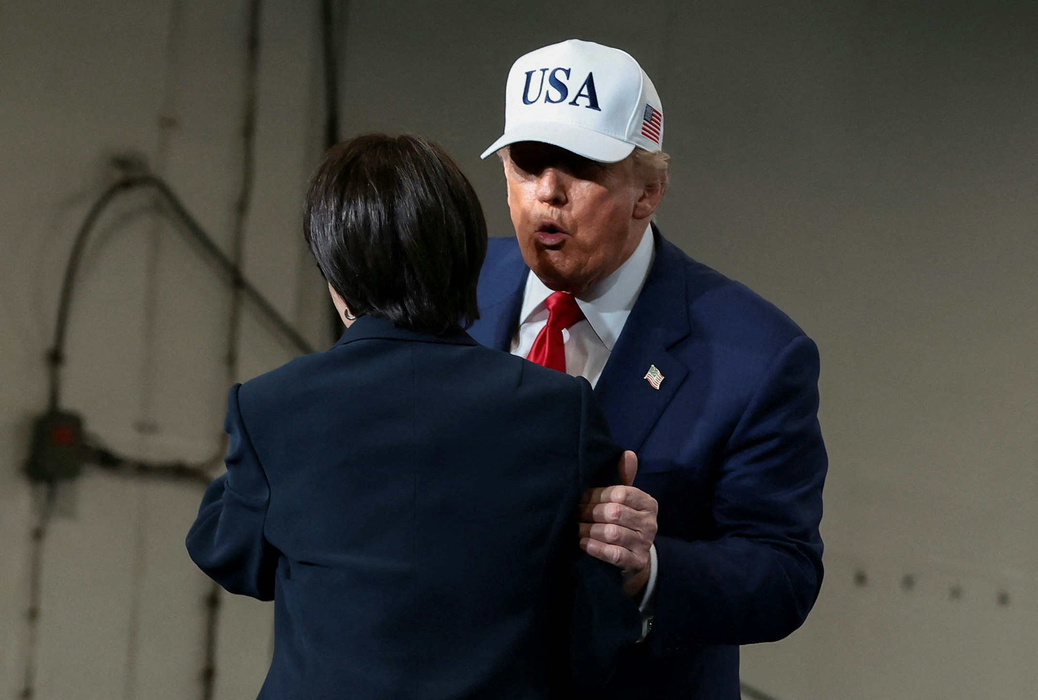 2025年10月28日，日本首相高市早苗在美國總統特朗普訪問美國海軍橫須賀基地，於「喬治華盛頓號」航空母艦上擁抱。（路透社)