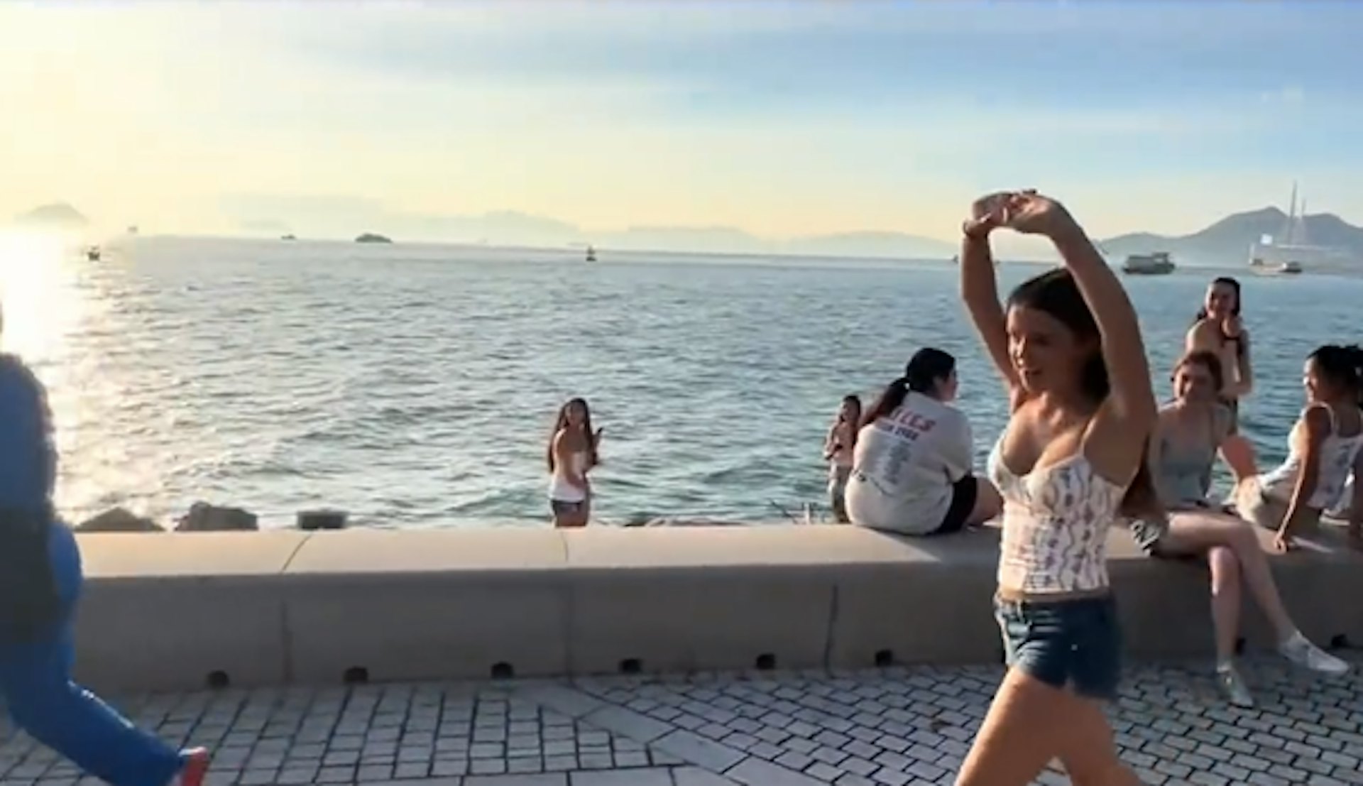 疑似外地遊客感到新奇,跟在「暴走團」後面模仿他們的動作。(影片截圖)