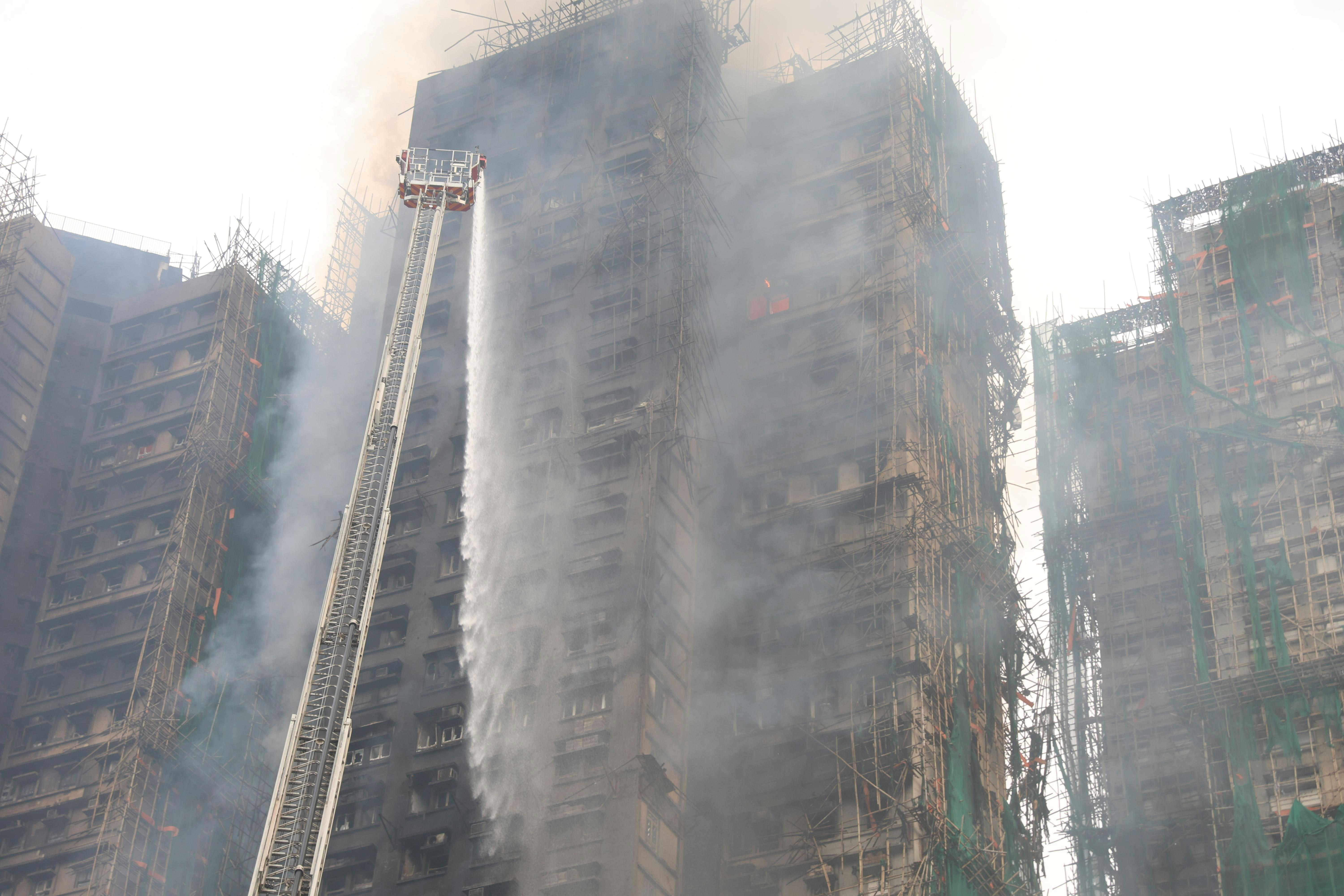 今日（27日）早上7時許，消防員不斷向大廈射水。（蔡正邦攝）