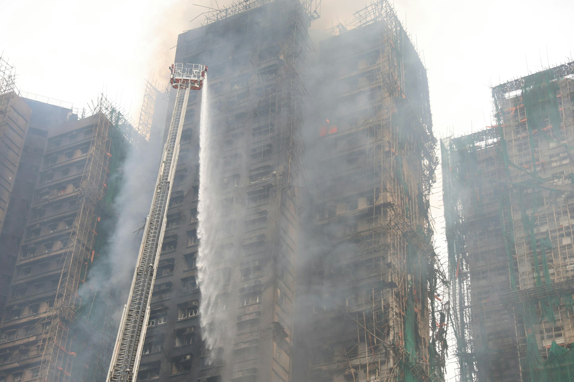 今日(27日)早上7時許,消防員不斷向大廈射水。(蔡正邦攝)
