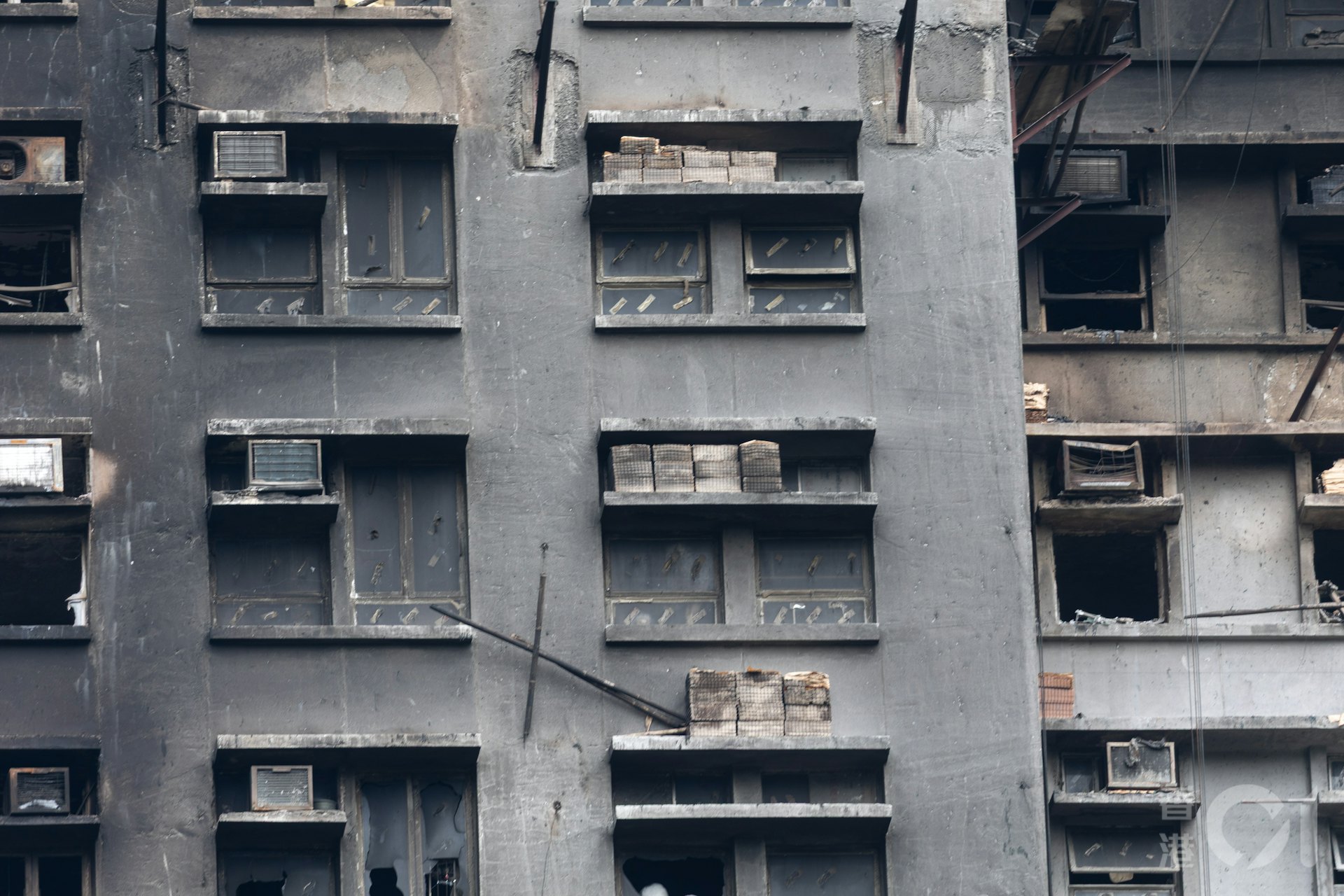 12月1日在大埔宏福苑可見,一些窗簷擺放了鋪設外牆的紙皮石,部份無爆破玻璃窗留有一條條膠紙,料是用來黏貼發泡膠板。(夏家朗攝) 12月1日在大埔宏福苑可見,一些窗簷擺放了鋪設外牆的紙皮石,部份無爆破玻璃窗留有一條條膠紙,料是用來黏貼發泡膠板。(夏家朗攝)