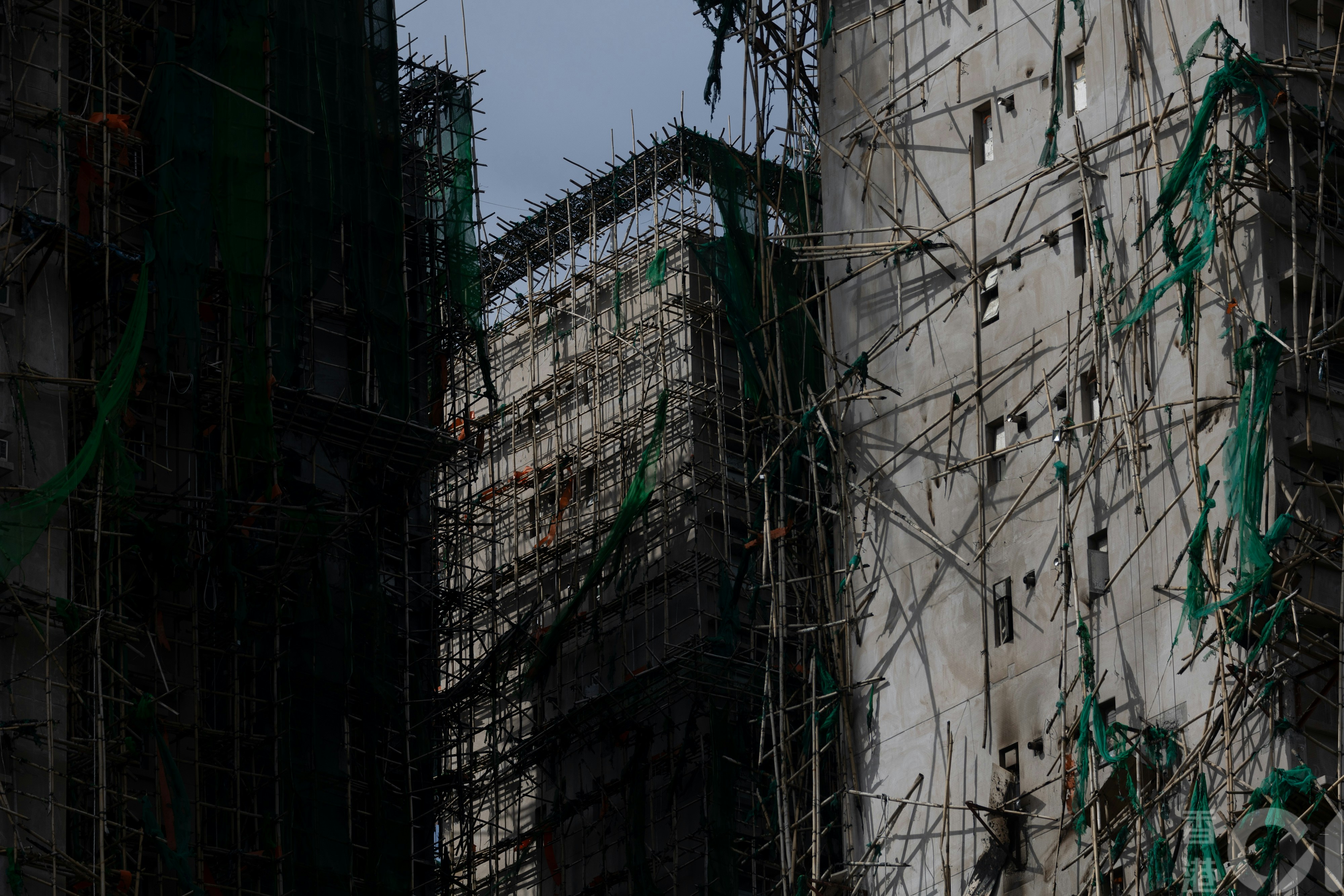 12月2日為大埔宏福苑大火死難者「頭七」,曾經是數千人的美好的家，外牆留下火災印記，竹棚和棚網掛在半空。（夏家朗攝）