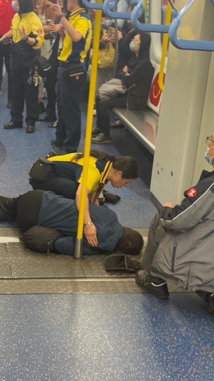 一名港鐵女職員不斷拍打事主試圖喚醒他，期間不斷稱「先生、先生！救護員嚟緊㗎喇！」（讀者提供）
