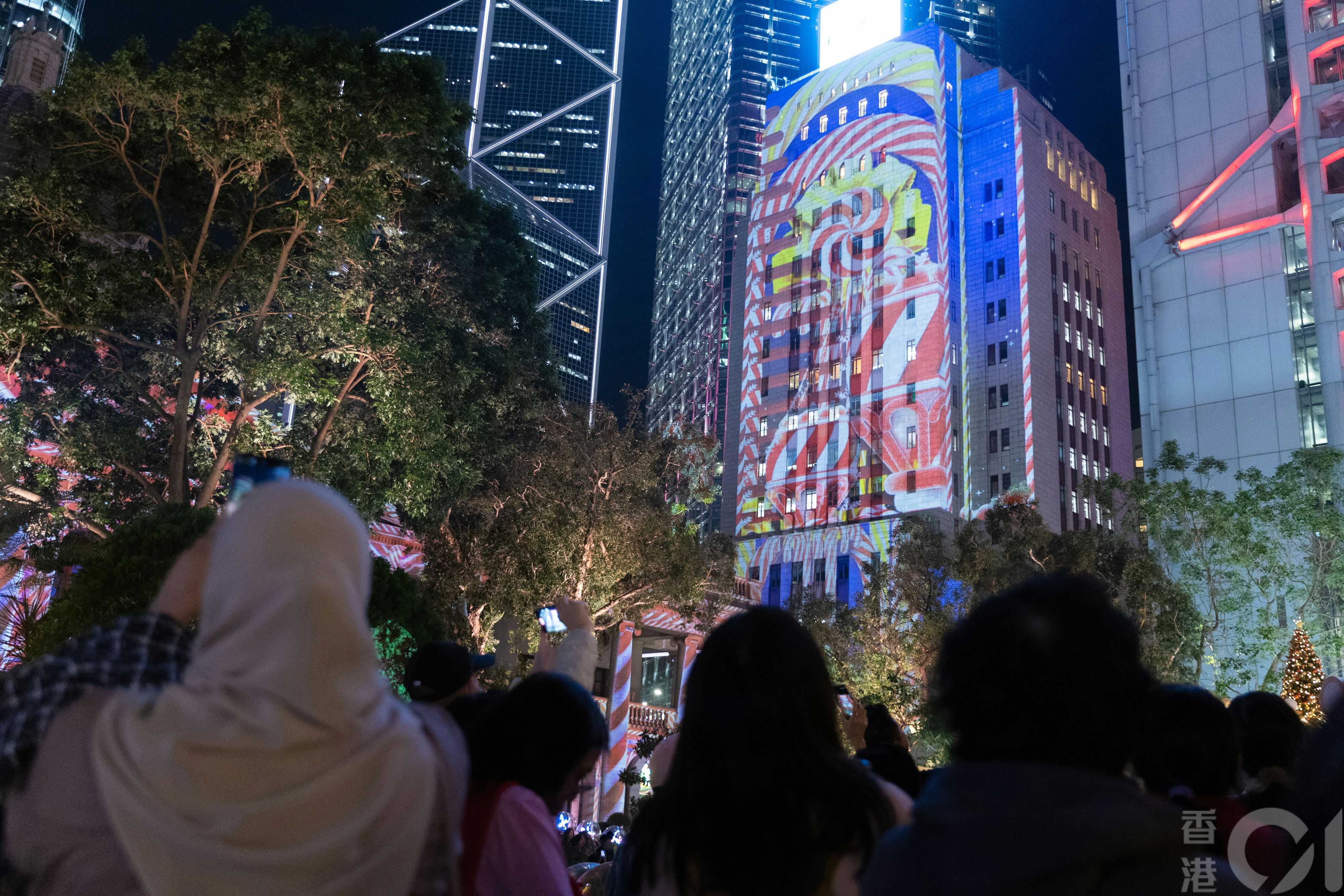 旅發局在中環皇后像廣場設置的聖誕裝置「冬日小鎮．中環」12月16日晚吸引不少人來觀賞和打卡，當中「光影匯·中環」燈光表演，令人不得不留步觀看。（夏家朗攝）