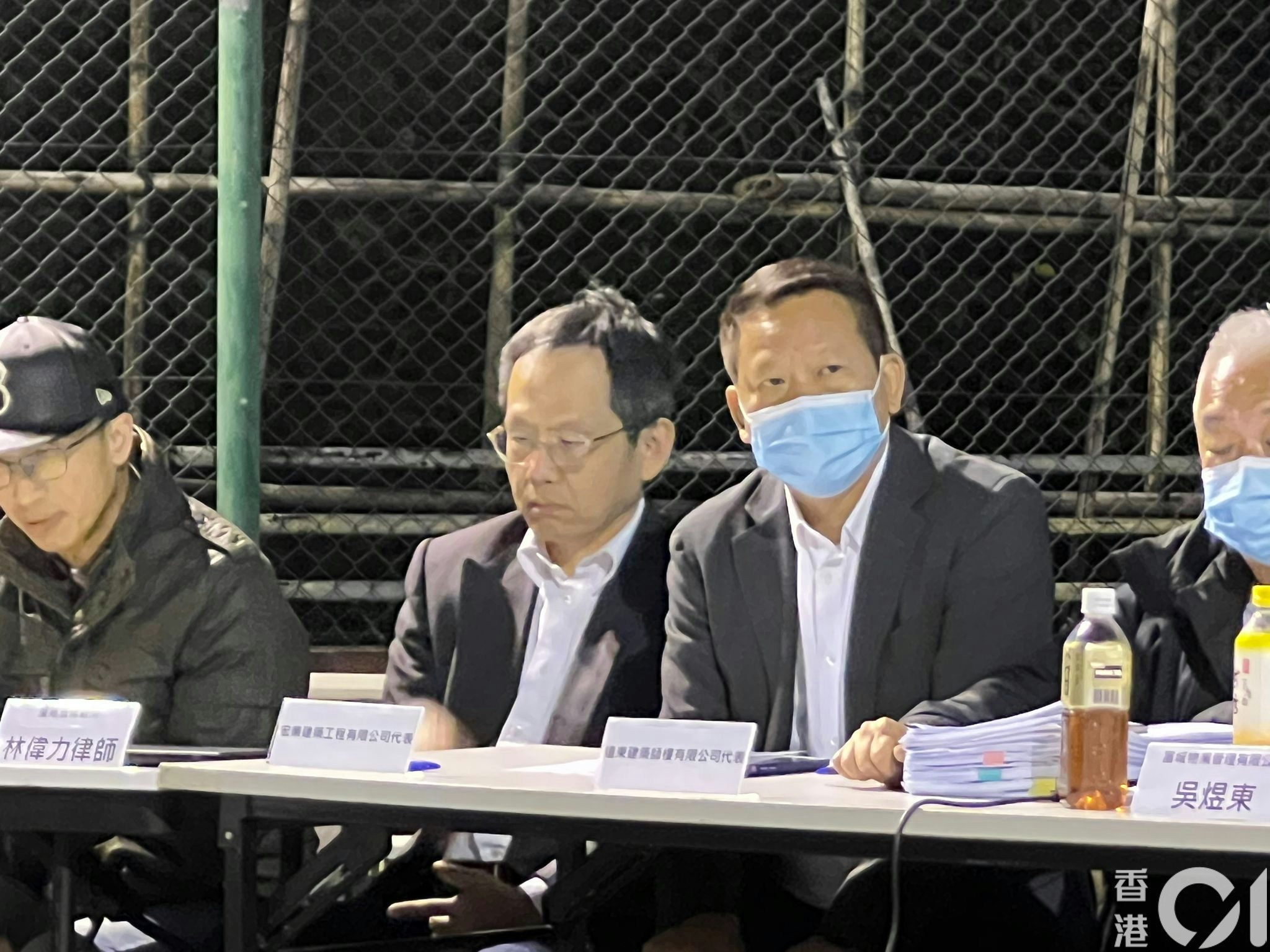 12月22日，宏業建築工程公司被捕董事侯華建（右二戴口罩者）現身屯門怡樂花園管委會「大維修工程特別會議」。（陳萃屏攝）