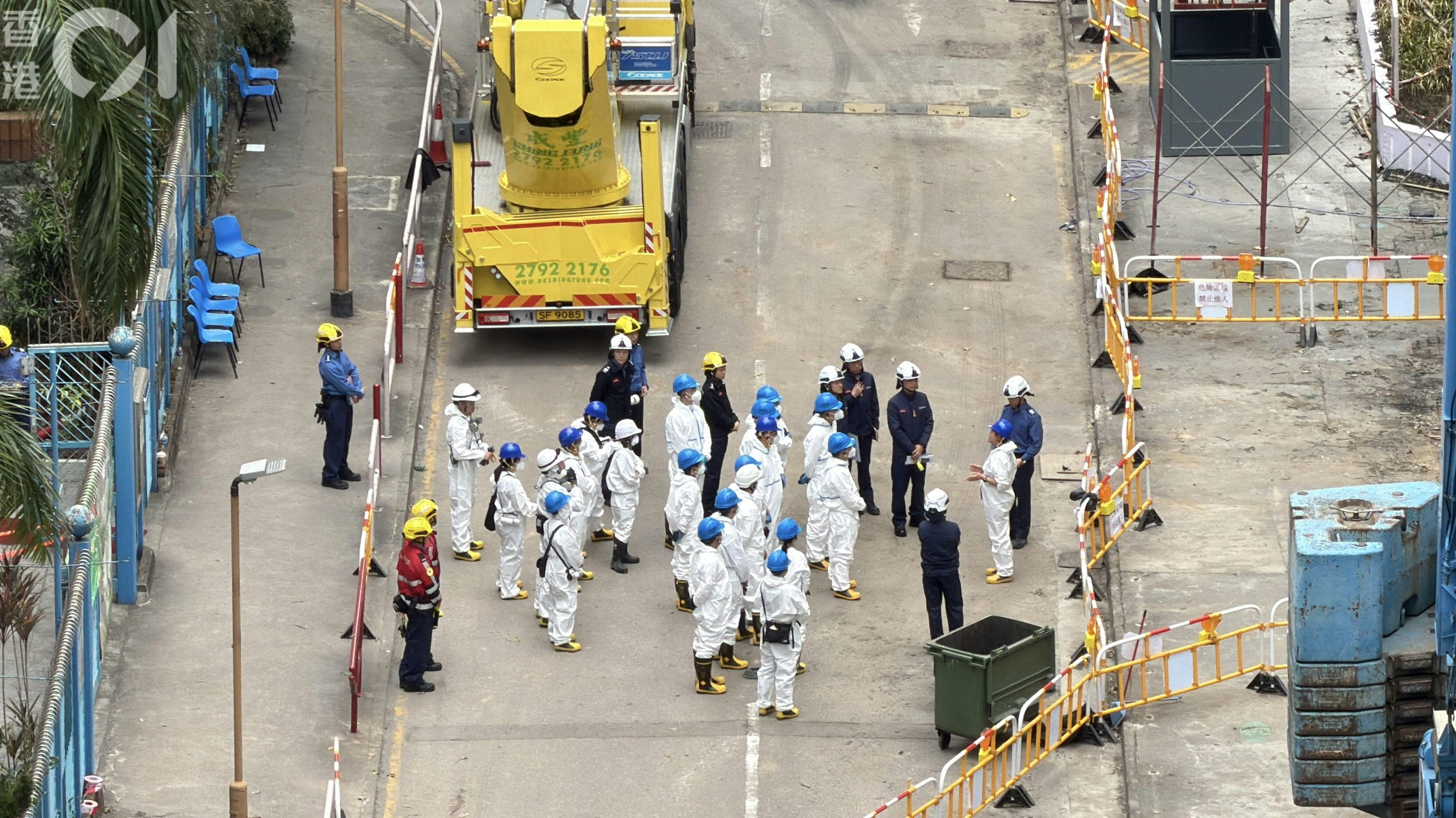 約40名身穿全身保護衣物的人員，抵達宏福苑。（馬耀文攝）