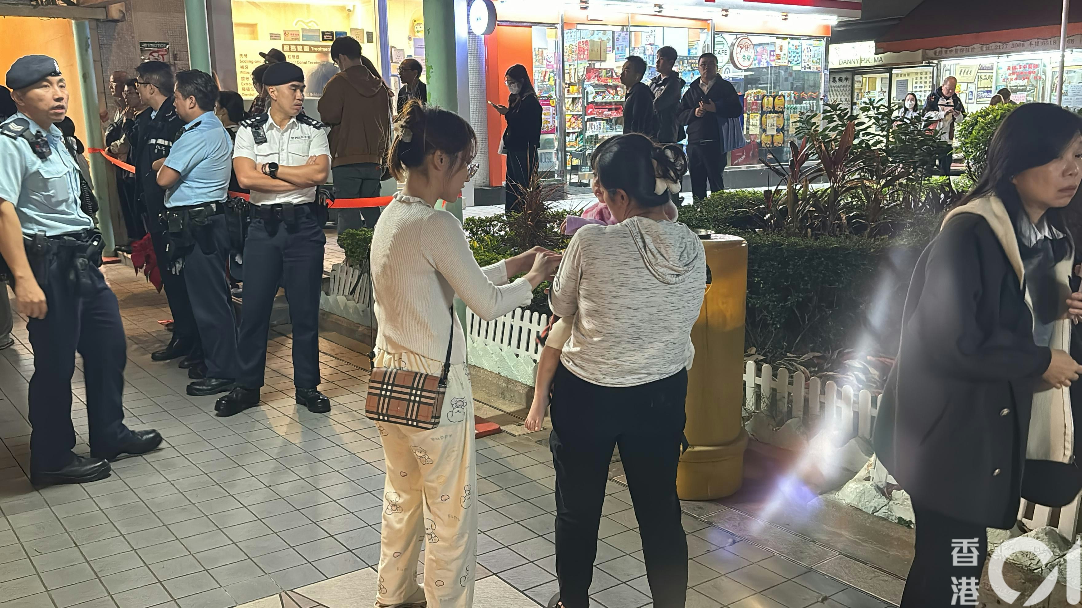 將軍澳安寧花園有單位起火，大批居民疏散，有人手抱幼童逃生。（陳浩然攝）