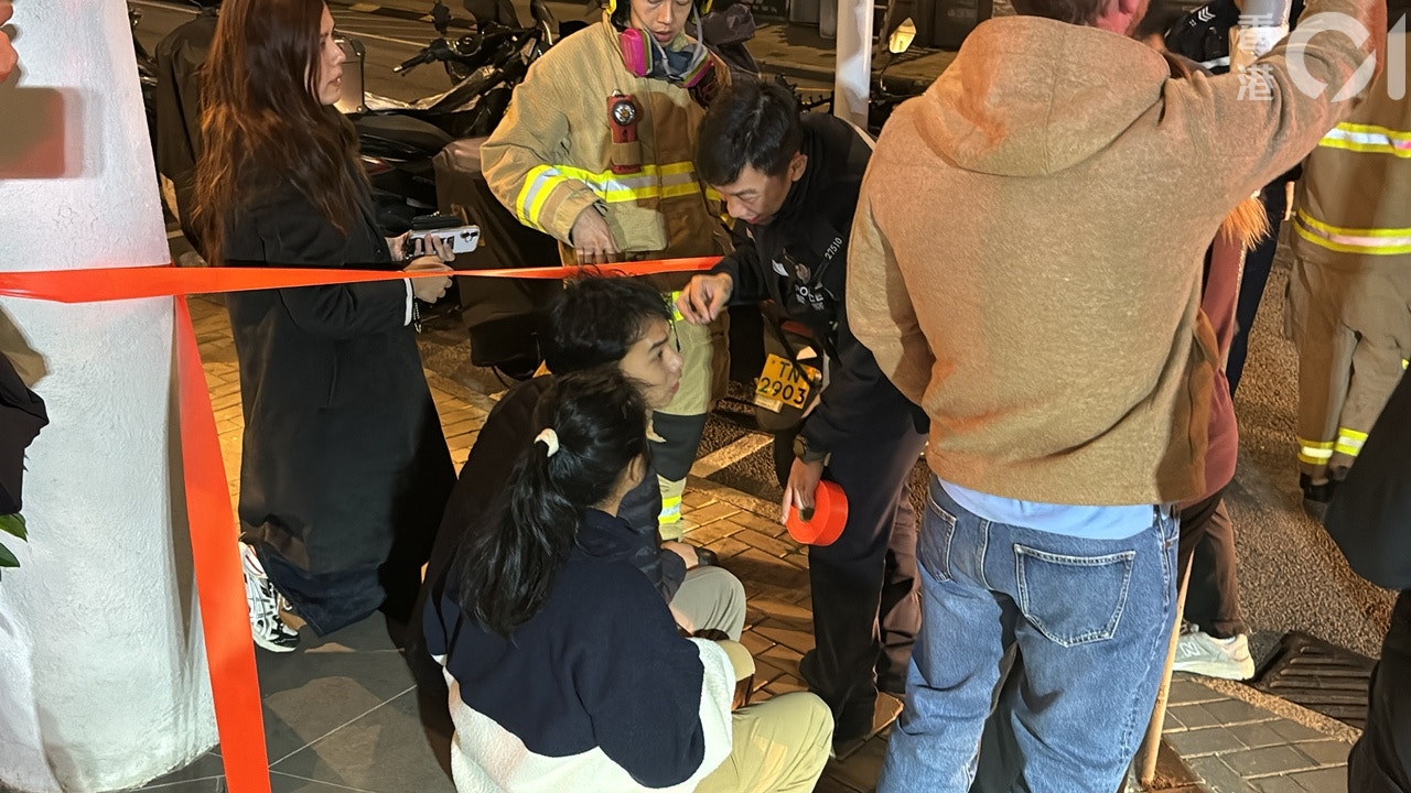 火警時有職員在店內，幸及時逃生，事後另有多名外籍男女趕返了解。（陳浩然攝）