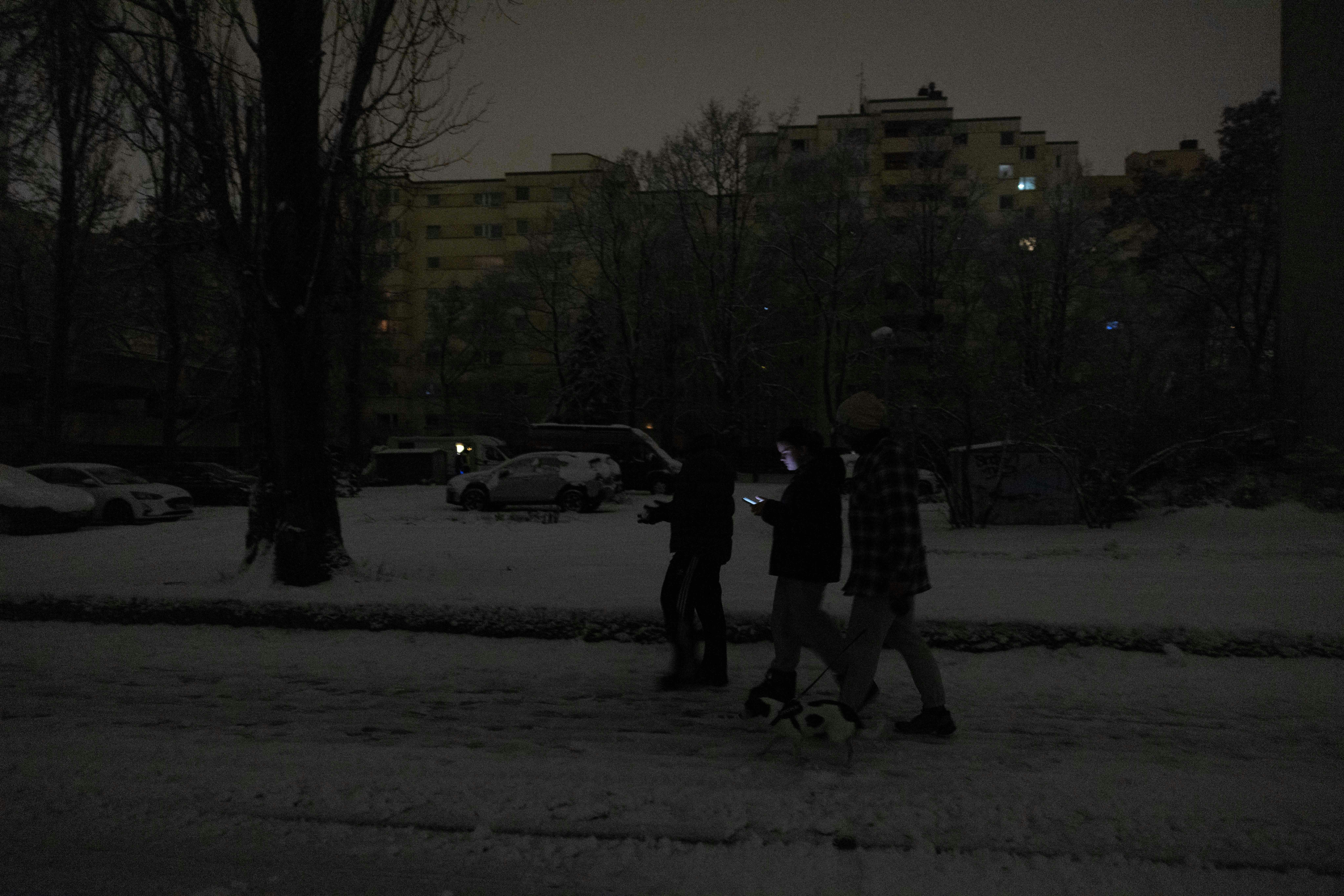 2026年1月3日，德國柏林一座電力配電系統發生火災，導致停電，人們走過昏暗的街道。（Reuters）