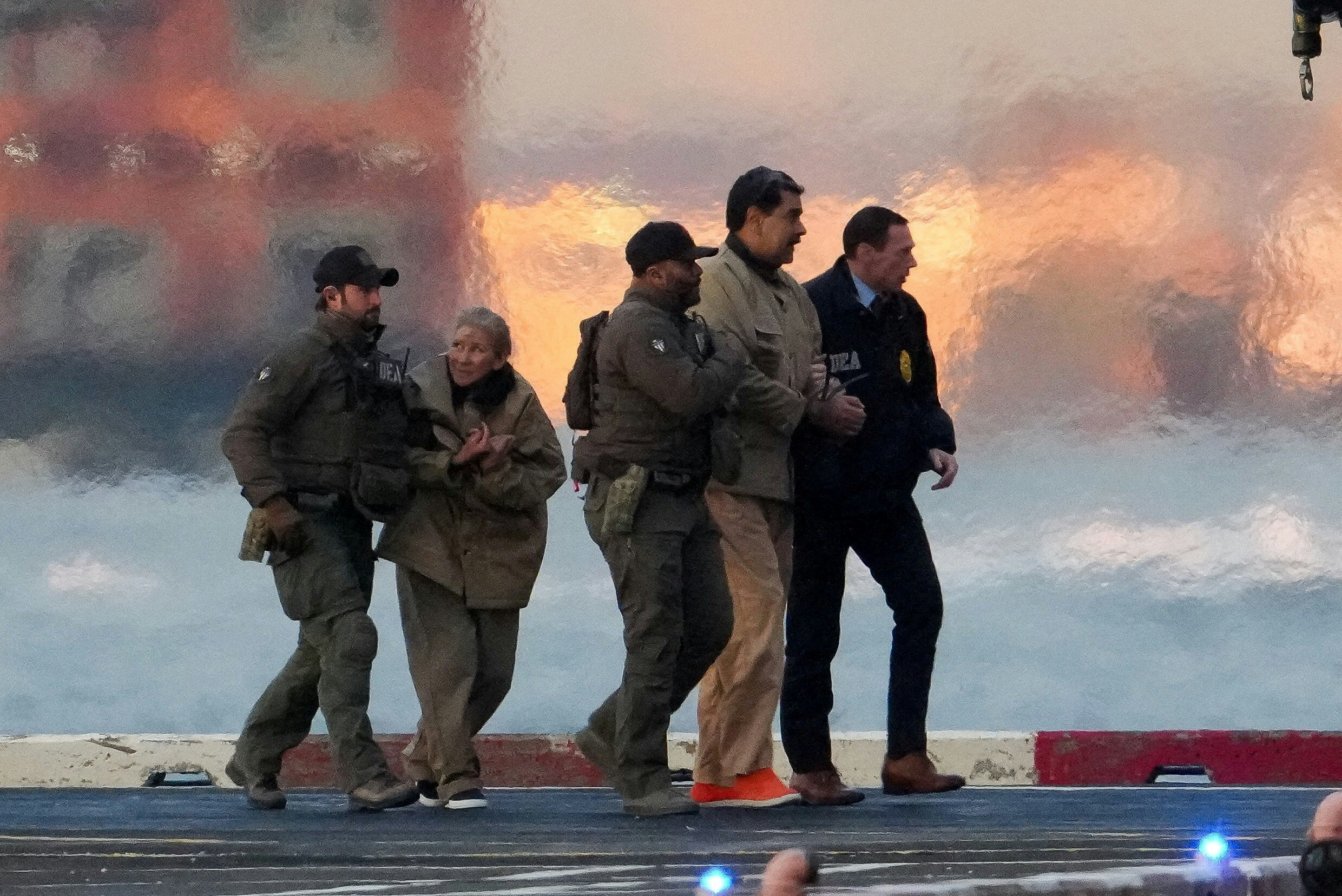 圖為 2026年1月5日，委內瑞拉總統馬杜羅（Nicolas Maduro，右二）與妻子（左二）由美國執法人員押送往紐約的聯邦法院。（Reuters）