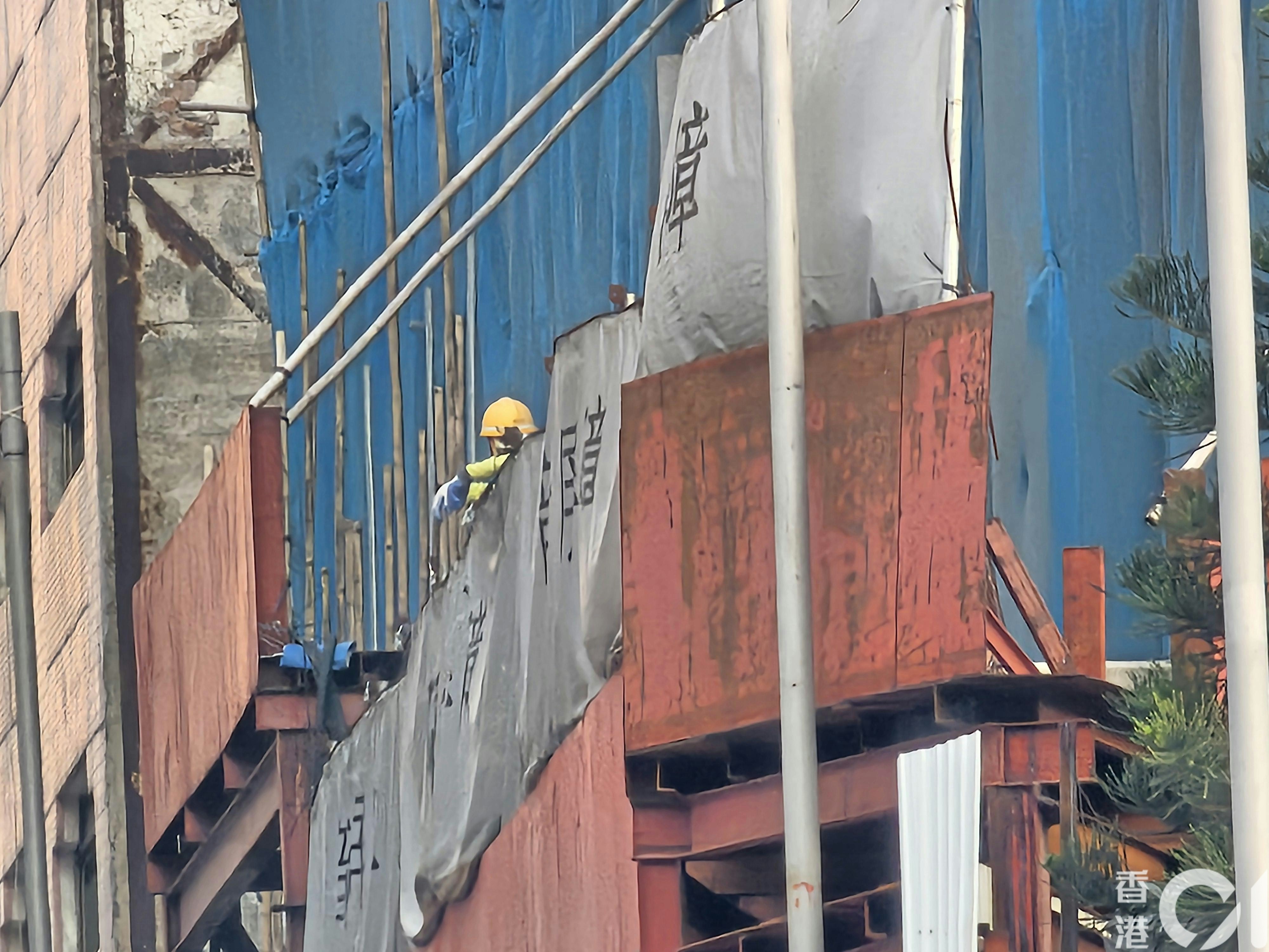 黃大仙飛鳳街有地盤棚網起火，熄滅後工人在場善後。（梁偉權攝）