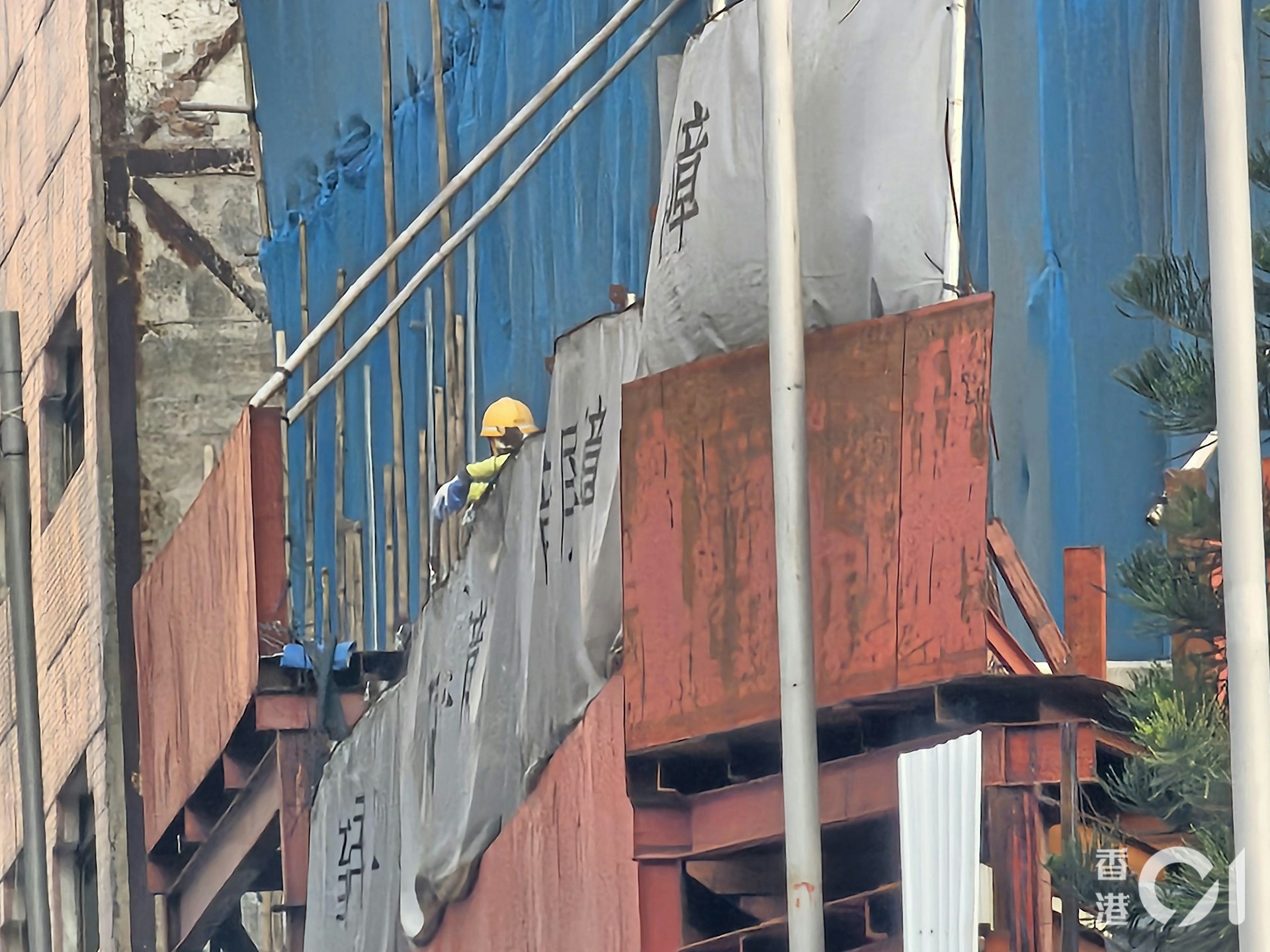 黃大仙飛鳳街有地盤棚網起火,熄滅後工人在場善後。(梁偉權攝) 黃大仙飛鳳街有地盤棚網起火,熄滅後工人在場善後。(梁偉權攝)