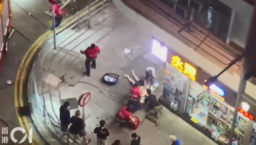 土瓜灣北帝街近新山道有唐樓單位爆炸，一名男子墮樓，救護員與熱心途人合力為他急救，其間救護員不時要抬頭查看，以防再有物品從樓上跌下。（讀者提供）