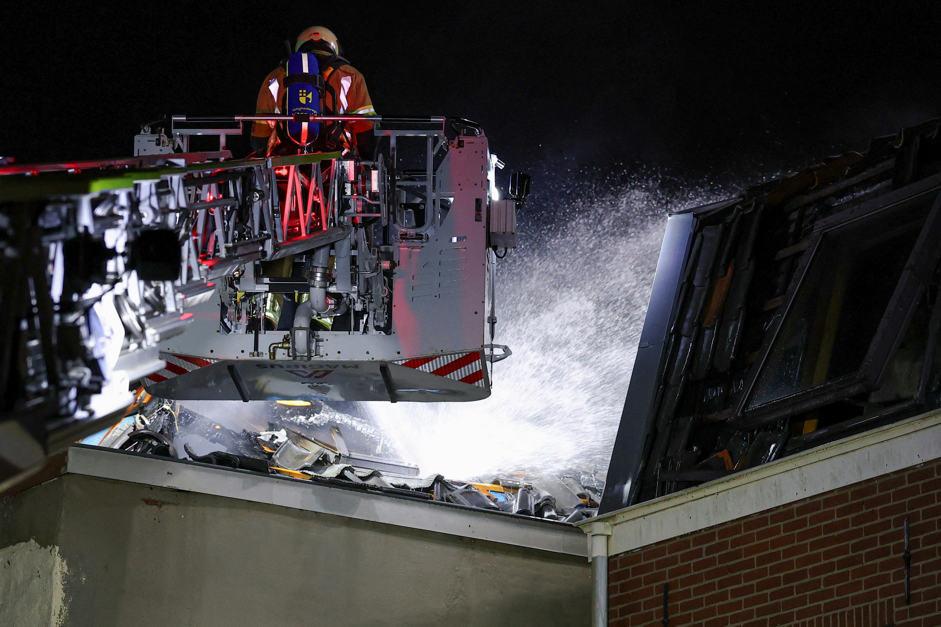 2026年1月15日，荷蘭烏得勒支市（Utrecht）市中心的一棟建築物發生爆炸起火，一名消防員正在現場進行滅火工作。（Reuters）