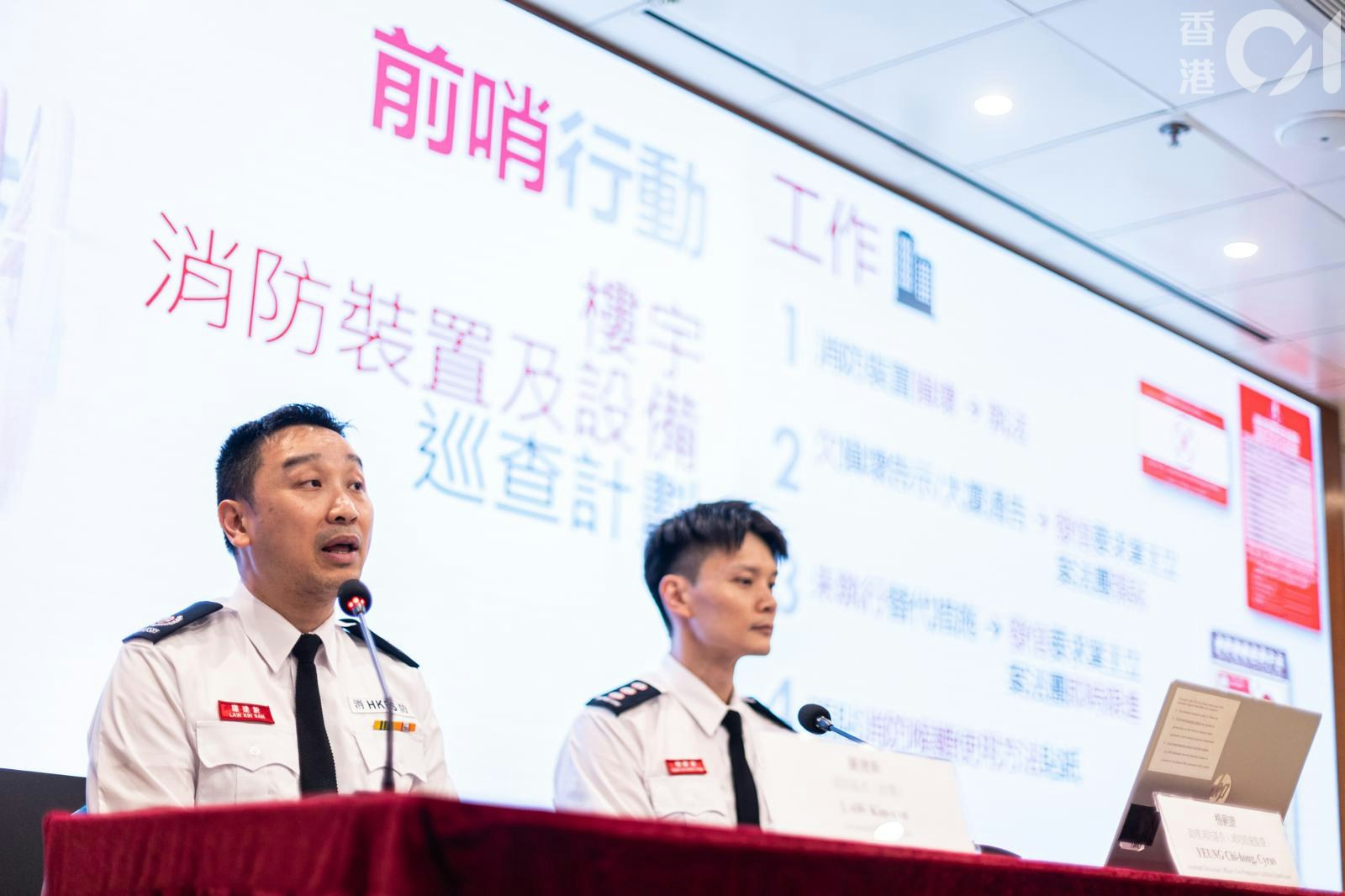 消防處今（19日）起，派出軍裝人員突擊巡查全港1,500棟舊式住用及綜合用途建築物。消防區長（政策）羅建新（左）、助理消防區長（消防設施監督）楊嗣康（右）講解新安排。（梁鵬威攝）