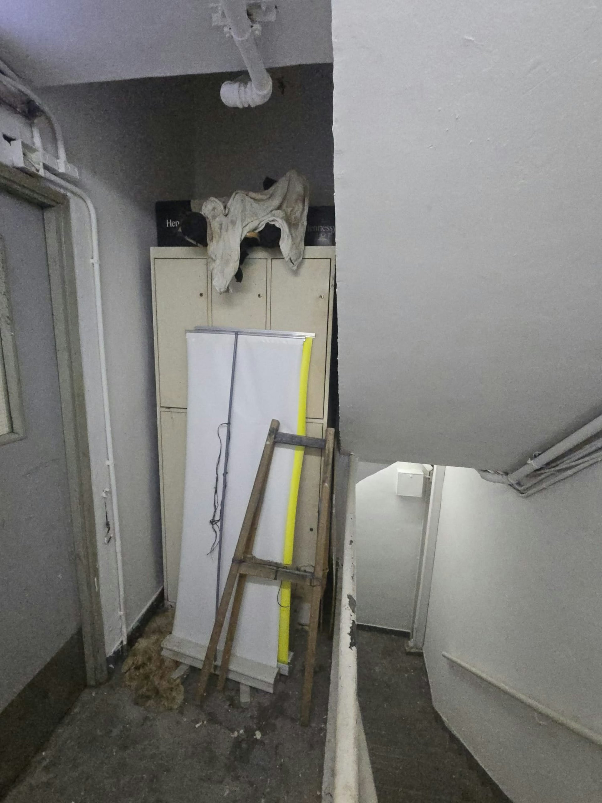 從讀者提供相片可見,在新興大廈後樓梯一個大型木櫃、易拉架、及木梯等雜物阻擋走火通道。(讀者提供) 從讀者提供相片可見,在新興大廈後樓梯一個大型木櫃、易拉架、及木梯等雜物阻擋走火通道。(讀者提供)