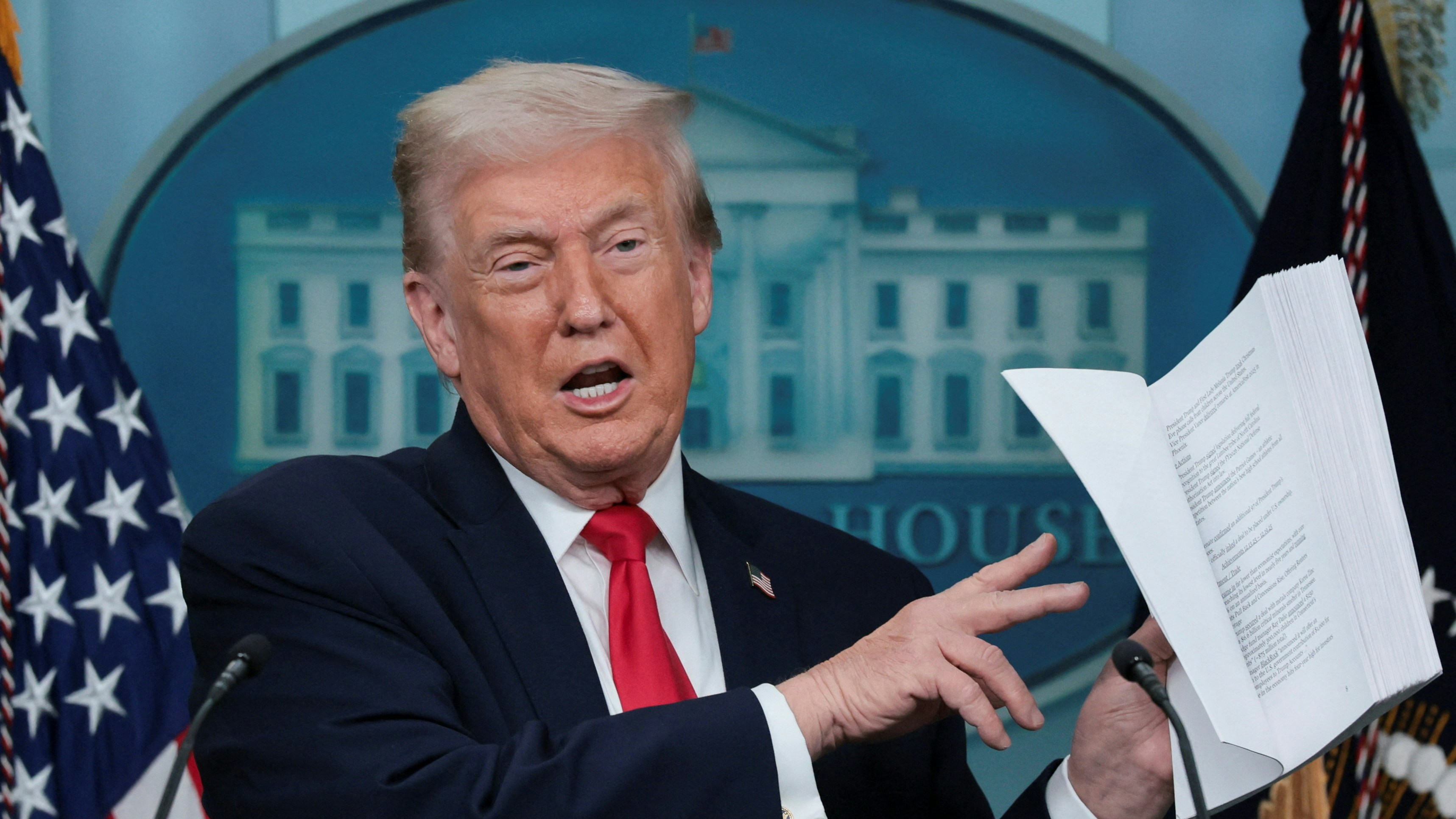 2026年1月20日，美國華盛頓，在其第二個總統任期滿一周年之際，特朗普（Donald Trump）在白宮舉行記者會發表講話。圖為特朗普手持一份文件，上面列舉了他過去一年的成就。（Reuters）