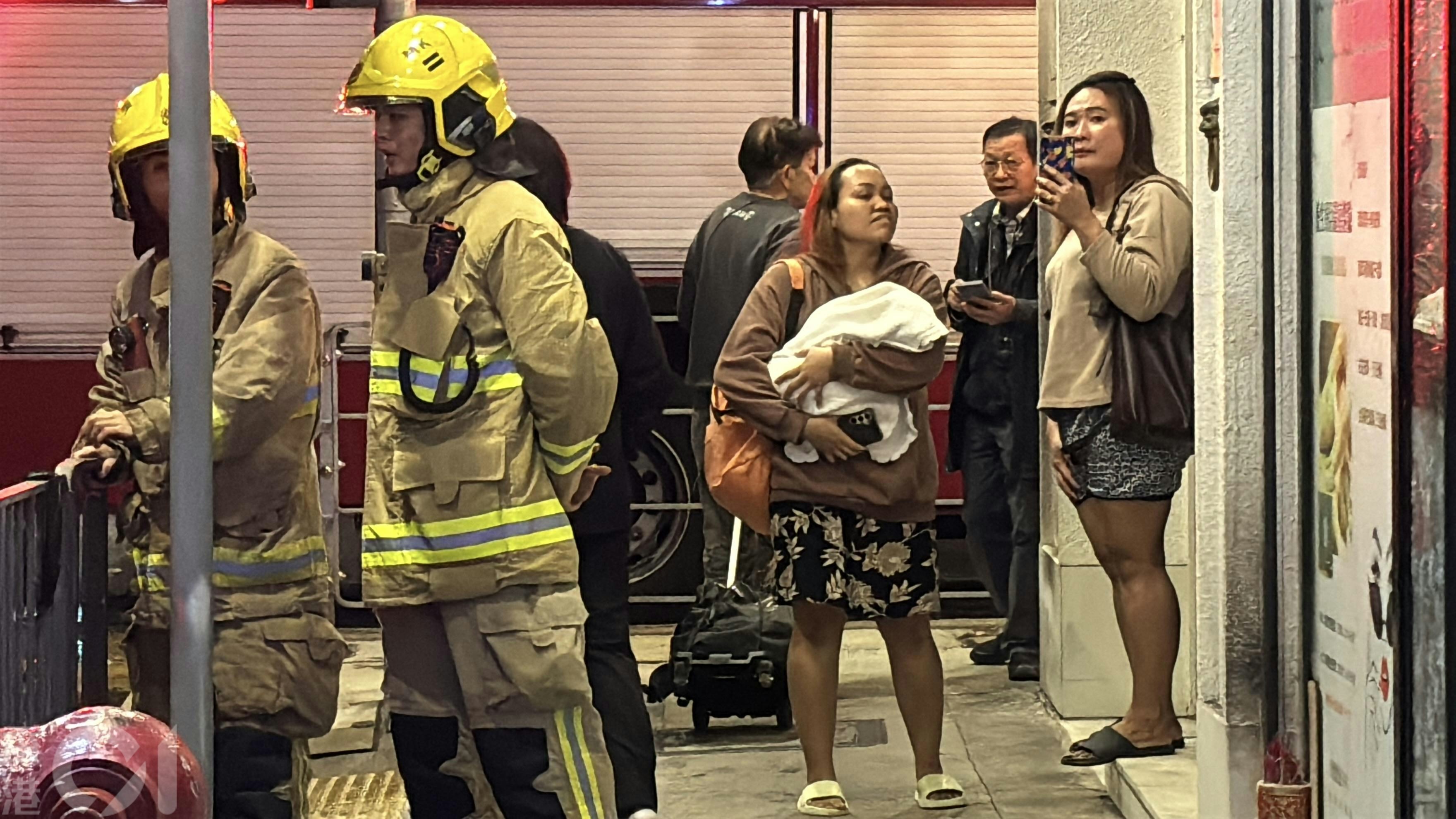 現場可見，有人手抱嬰兒在地面等候。（林振華攝）