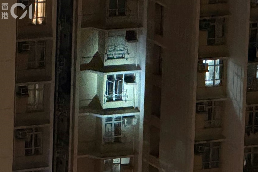 火警救熄後，消防用大光燈照亮單位調查。(讀者圖片)