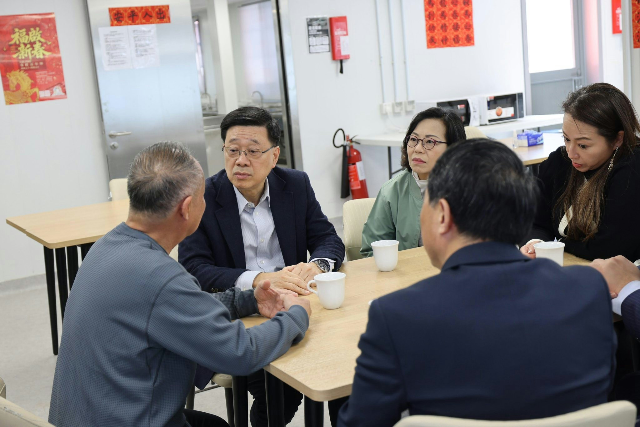 行政長官李家超2月13日探訪暫住在「啟航1331」的大埔宏福苑居民，了解他們對長遠安置方案的看法。（李家超Facebook）