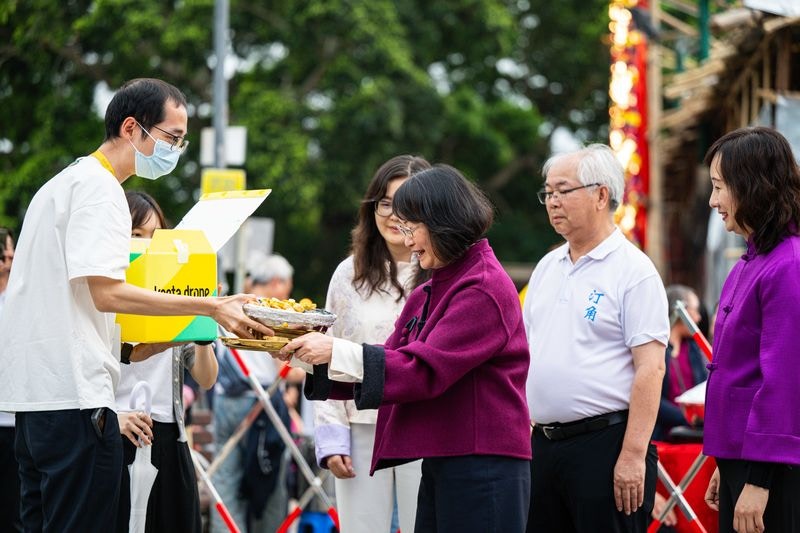 大埔及北区福利专员冯曼瑜接过盆菜模型。（美团图片）