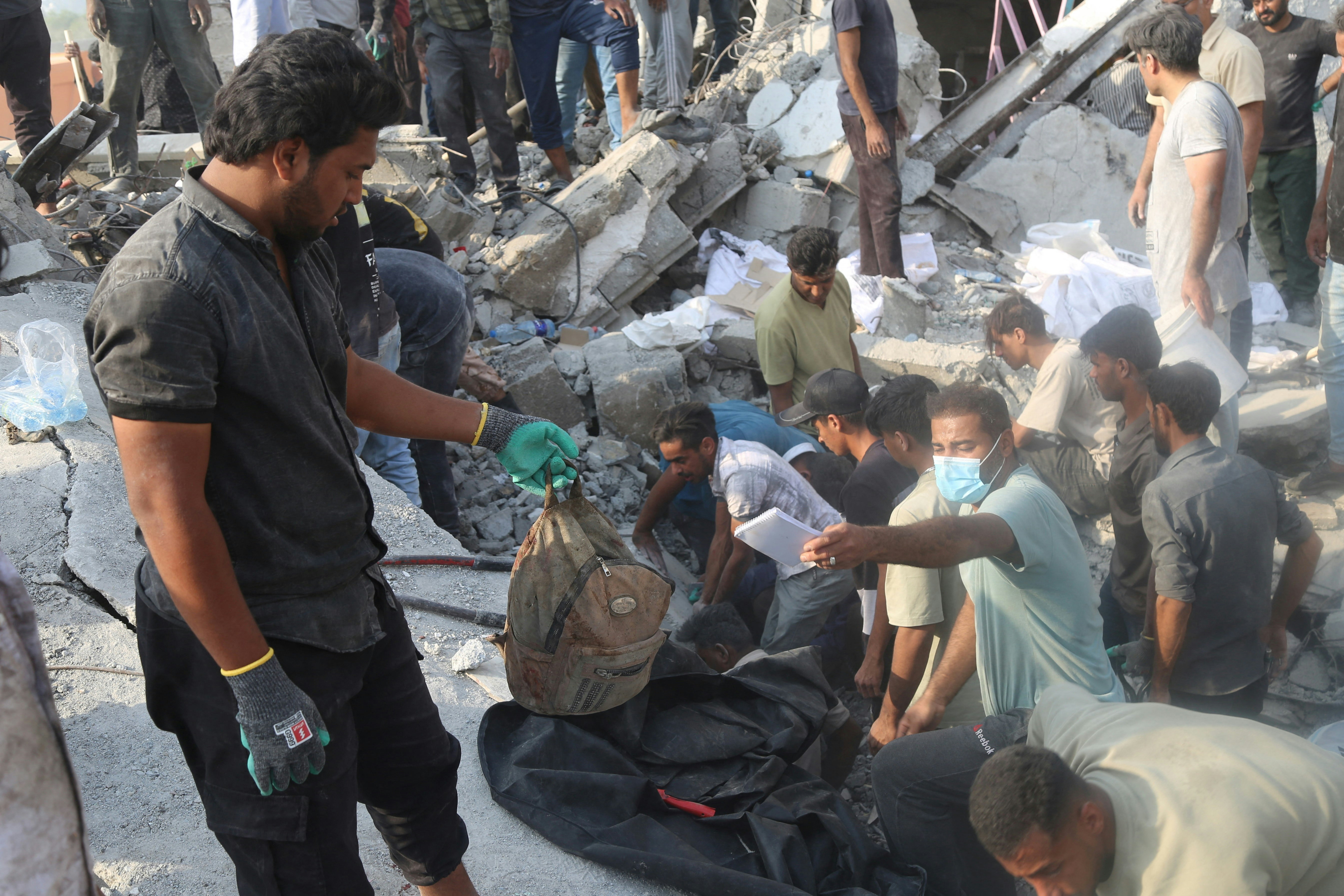 2026年2月28日，美國、以色列與伊朗爆發衝突期間，伊朗米納布一間學校遇襲造成多名學童死傷，民眾及救援人員在現場展開救援工作。（Reuters）