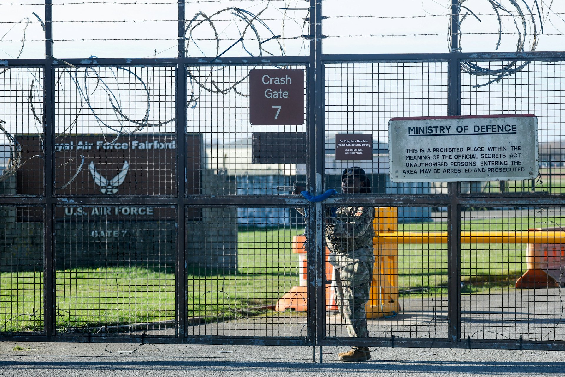 2026年3月2日,在英國費爾福德,一名美軍士兵在皇家空軍費爾福德基地外圍圍欄上加固大門。(Reuters) 2026年3月2日,在英國費爾福德,一名美軍士兵在皇家空軍費爾福德基地外圍圍欄上加固大門。(Reuters)