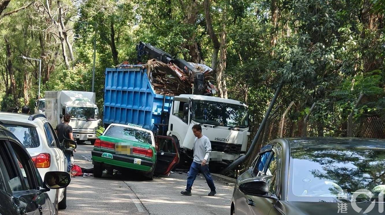 身穿紅衣的老婦被救出車廂，倒臥在的士旁。（讀者陳先生提供）