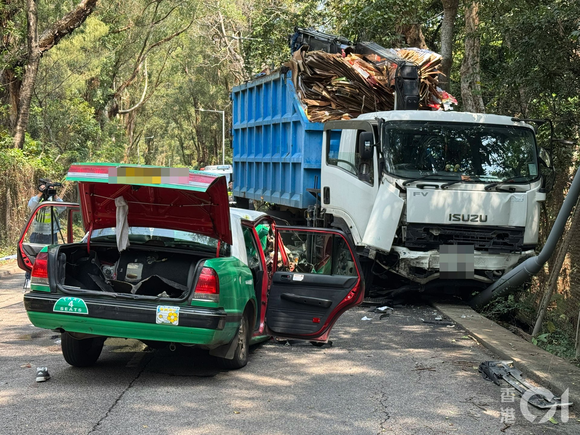 的士車頭嚴重損毀;夾斗車車頭亦撞至凹陷,並撞毀左邊一支燈柱。(蔡正邦攝)
