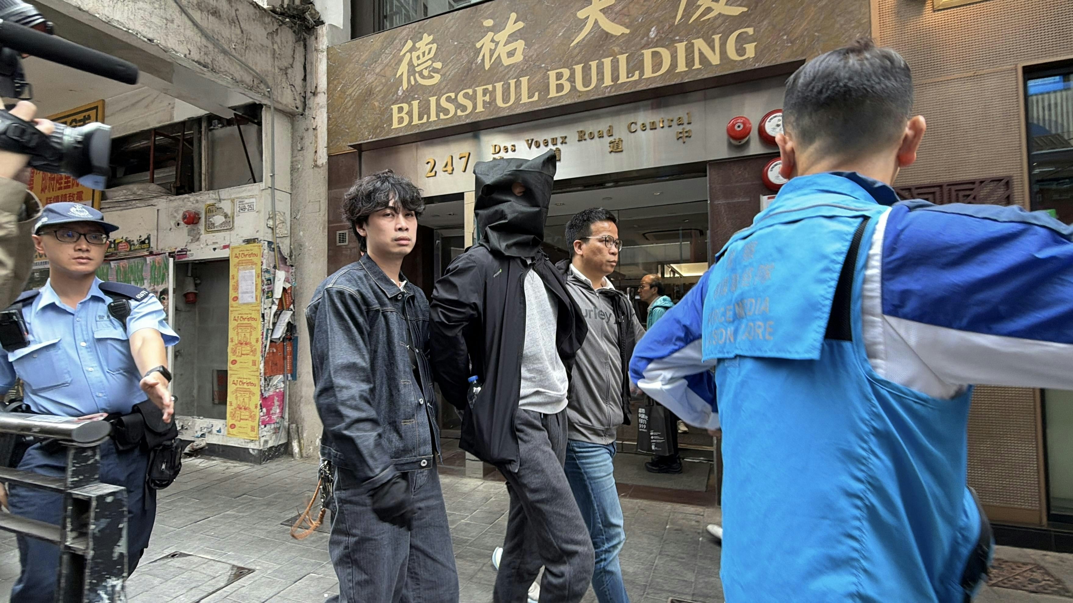 O記探員將一名穿黑色外套及灰色衫被捕人帶出地鐵站。（黃煦緻攝）