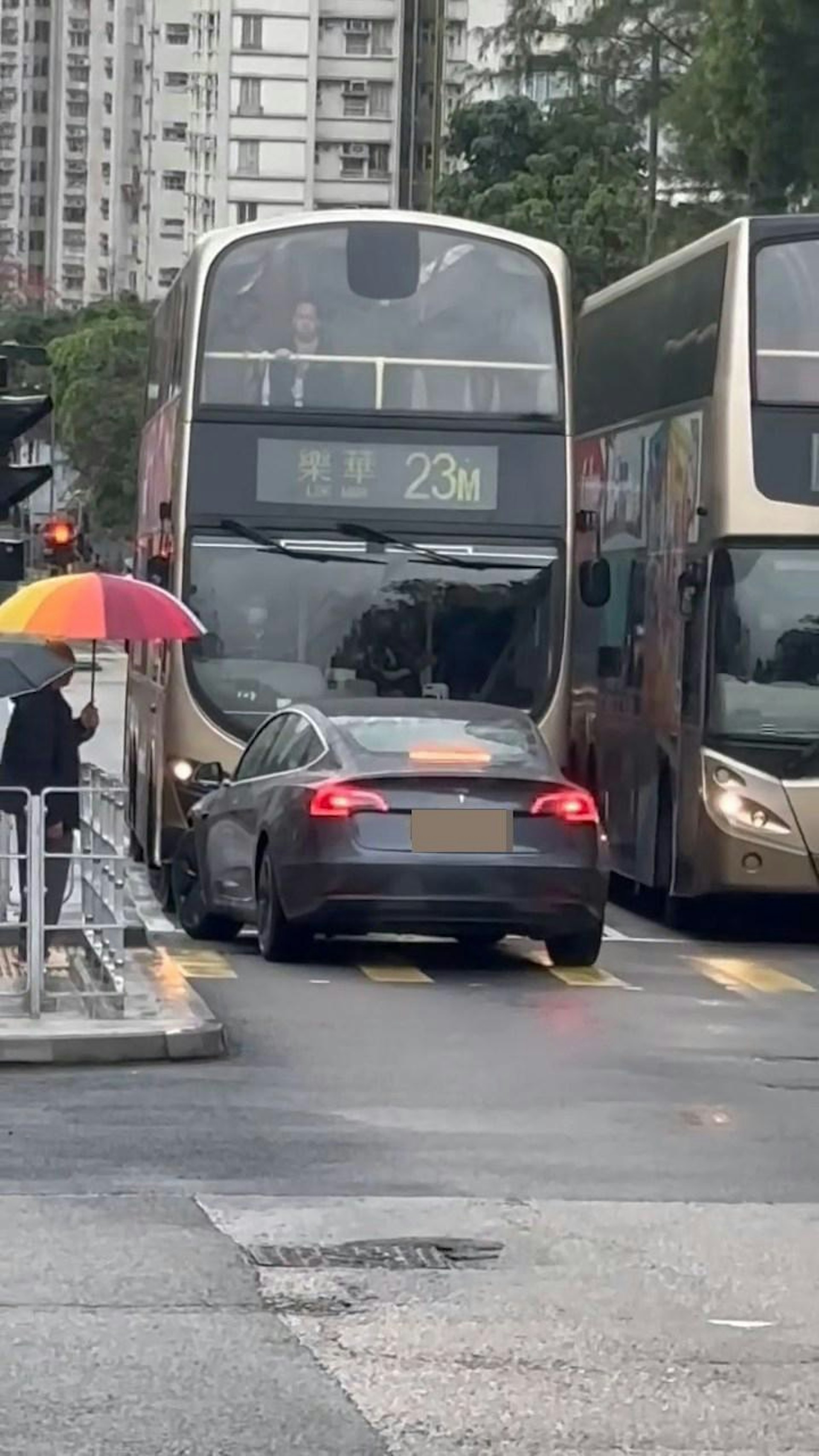 觀塘有Tesla私家車逆線行車,在一個紅綠燈斑馬線位置被2架九巴包圍阻擋。(Facebook群組「車cam L(香港群組)」)
