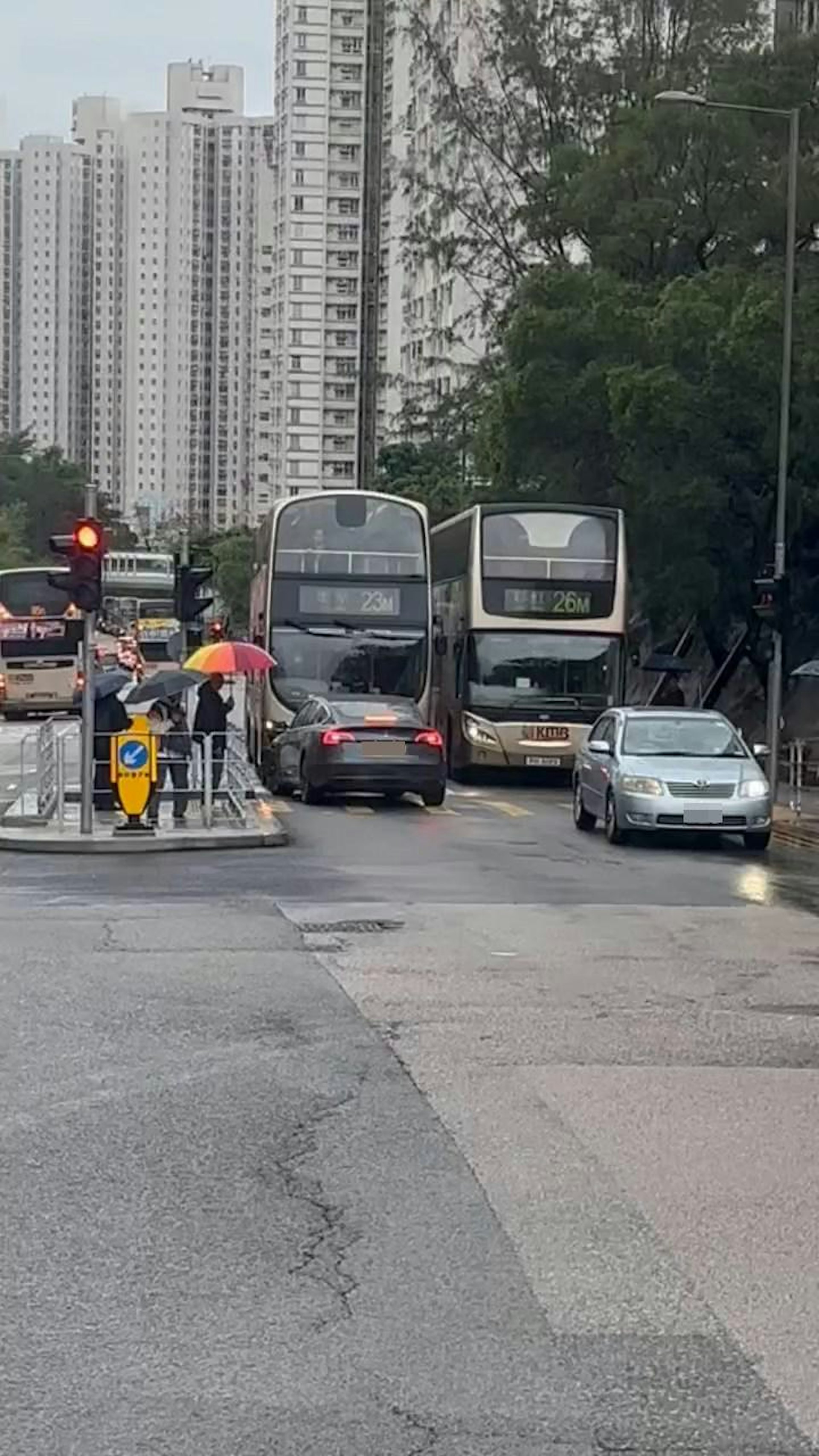 Tesla整個車身踩在斑馬線上,前方及右方有2部巴士。(Facebook群組「車cam L(香港群組)」)