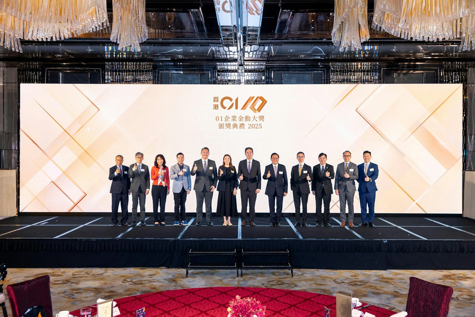2026年3月20日,《香港01》舉辦第六屆「01企業金勳大獎」頒獎禮,《香港01》代表與嘉賓合照,包括《香港01》行政總裁蘇曉婷(左六)、商務及經濟發展局副局長陳百里(左七)和行政會議非官守議員林健鋒(左八)等。(《香港01》圖片)