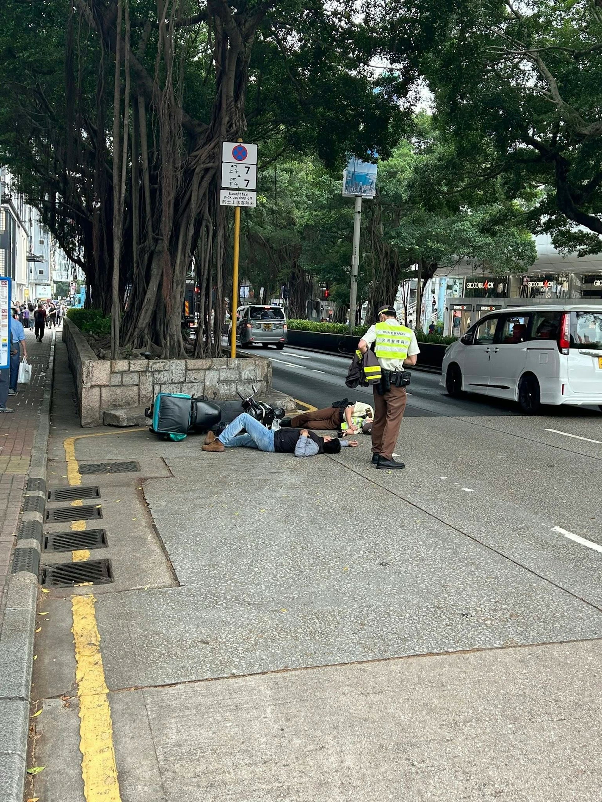 網上圖片可見,涉事電單車翻側在路邊;鐵騎士及交通督導員雙雙倒地躺臥馬路。(fb/馬路的事討論區 Andy Lee)