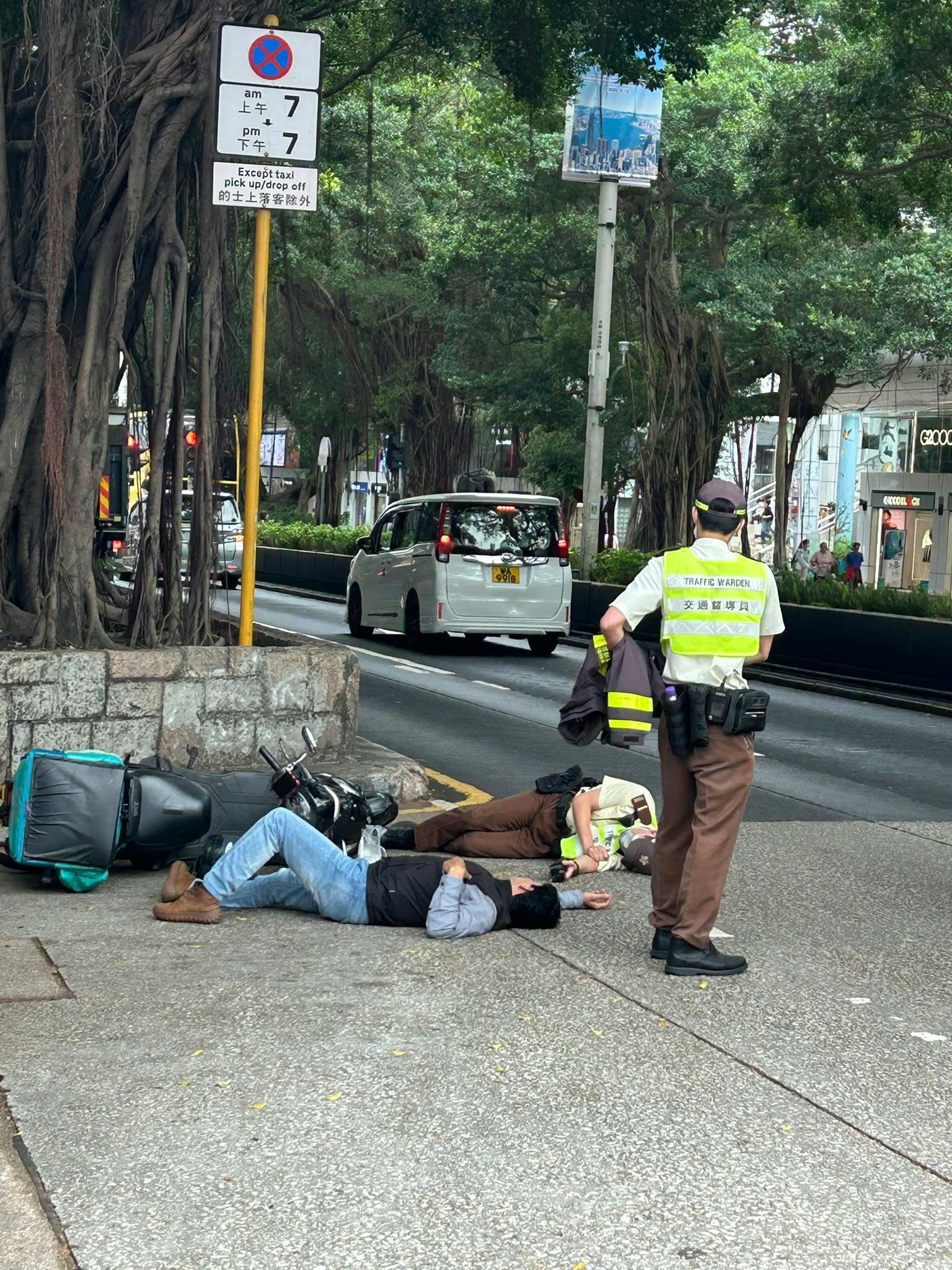 網上圖片可見，涉事電單車翻側在路邊；鐵騎士及交通督導員雙雙倒地躺臥馬路。（fb／馬路的事討論區 Andy Lee）