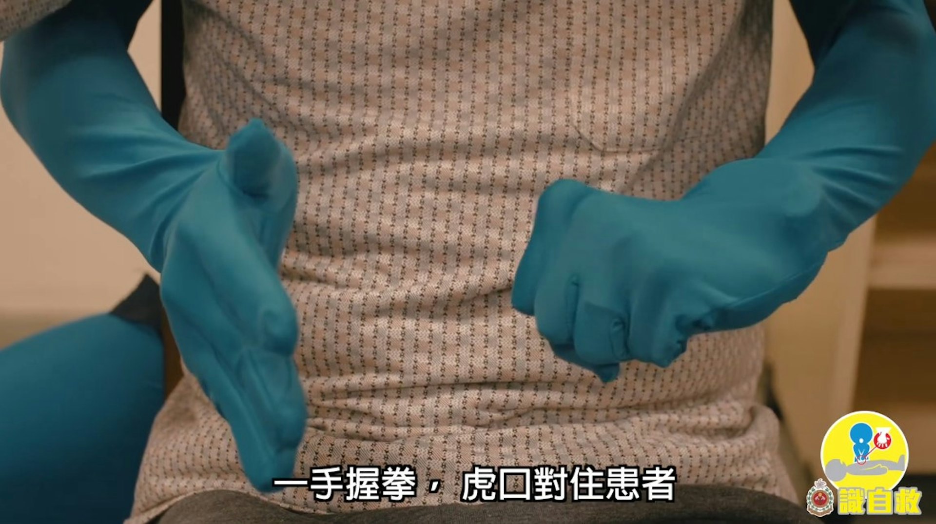 鯁喉患者「謙烈治法」急救步驟2:一手握拳,拇指及虎口位朝向患者(消防處YouTube片段截圖)