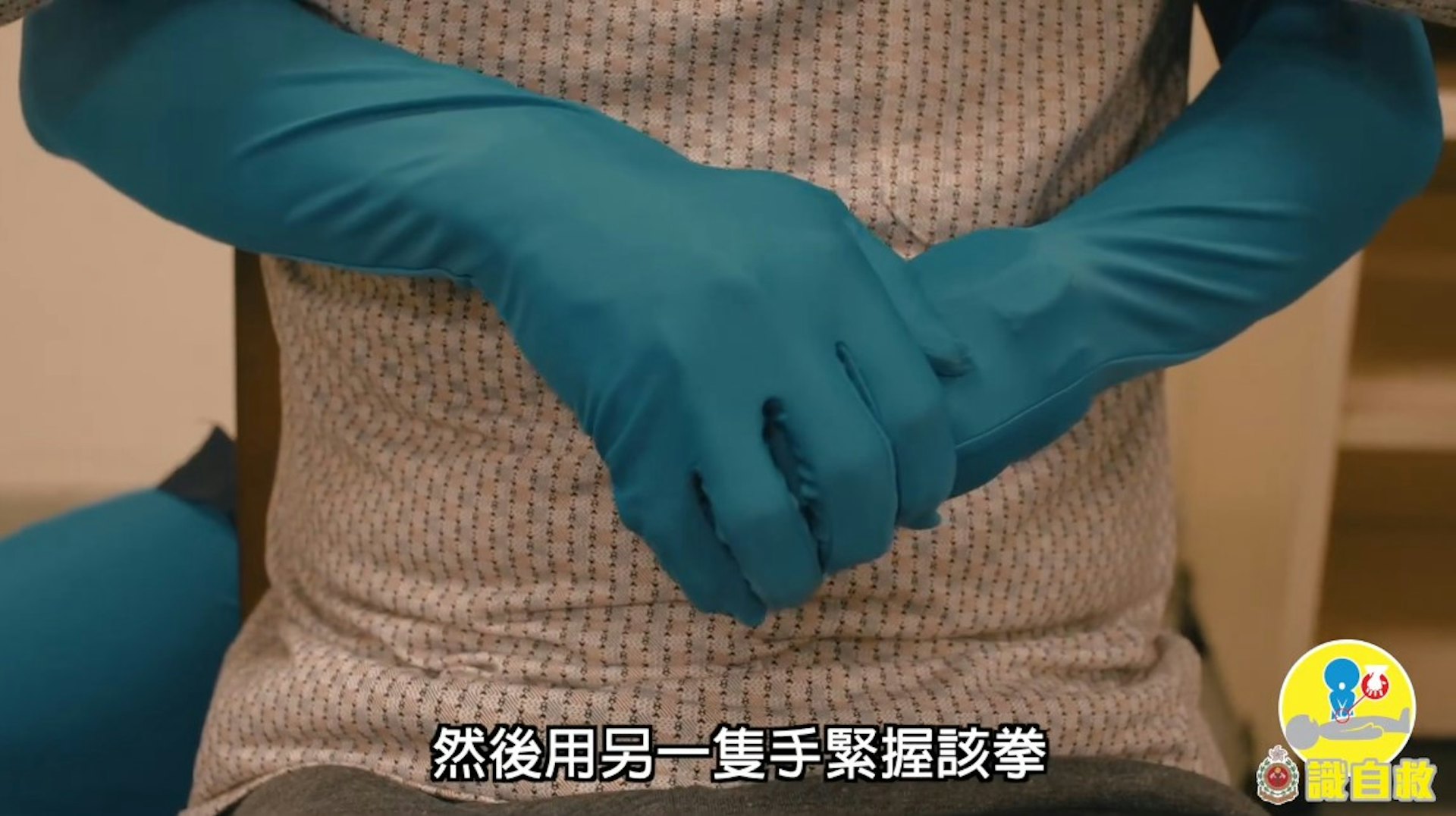 鯁喉患者「謙烈治法」急救步驟3:用另一隻手緊握該拳(消防處YouTube片段截圖)