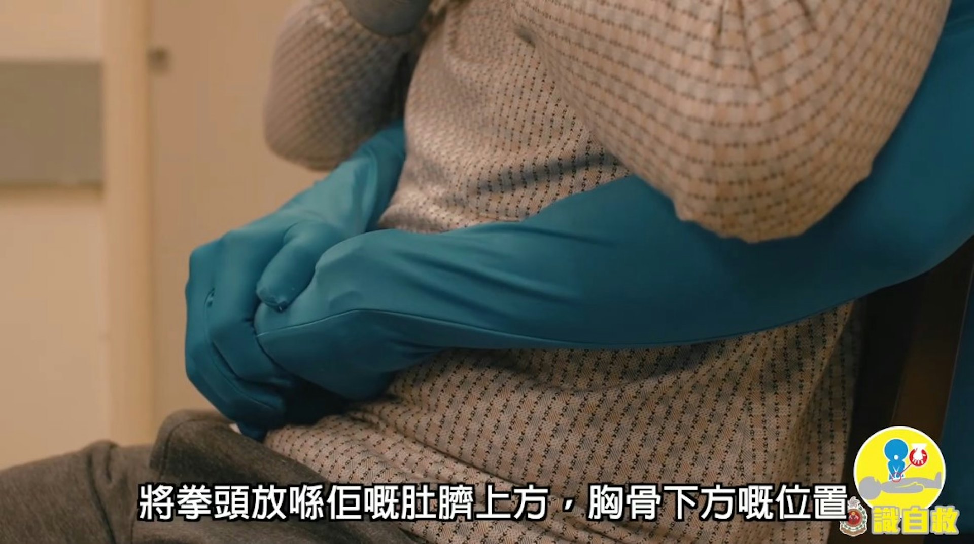 鯁喉患者「謙烈治法」急救步驟4:雙手放在患者的腹部中線,稍高於肚臍,但遠低於胸骨劍突尖的位置(消防處YouTube片段截圖)