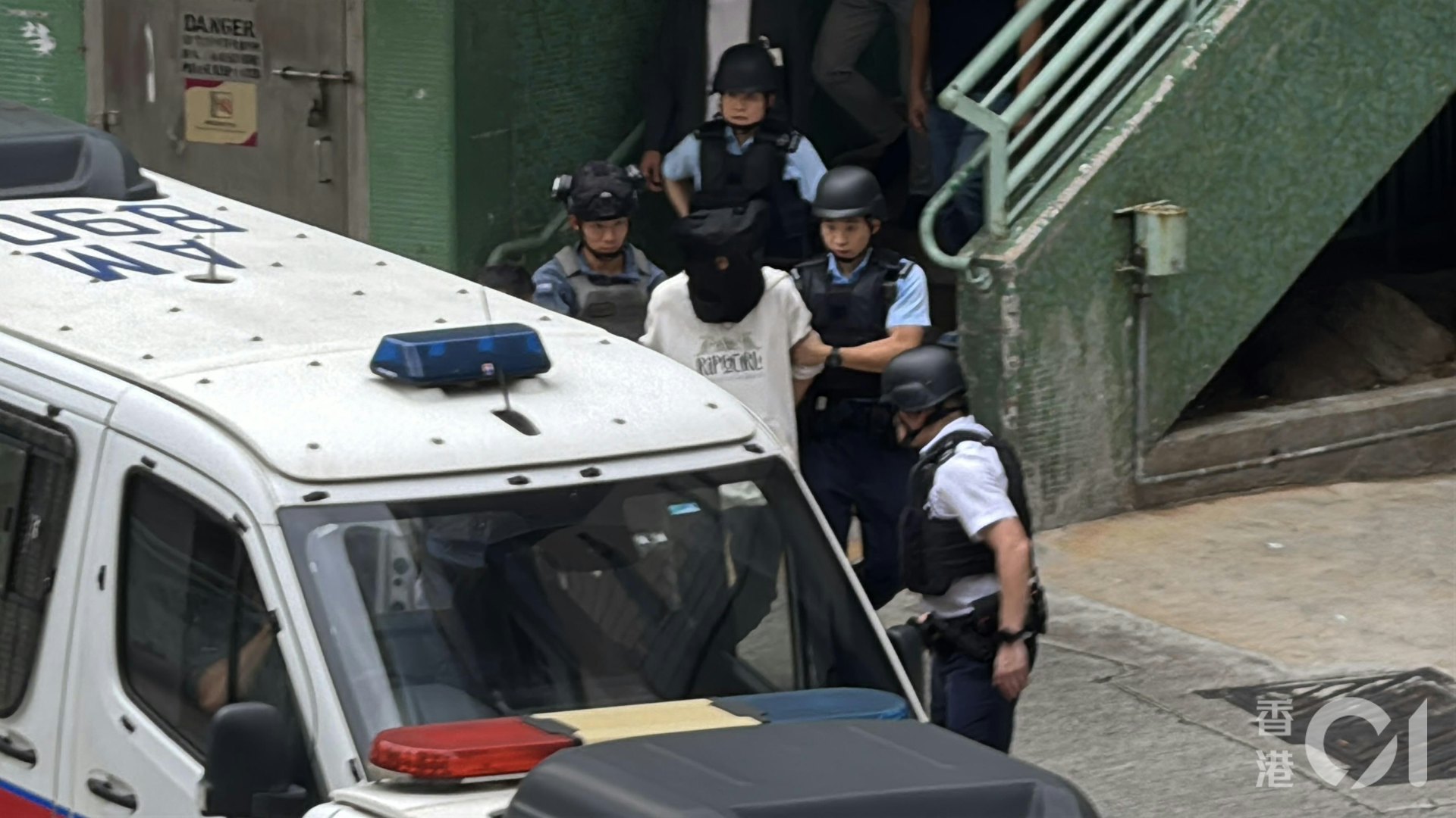 疑犯黑布蒙頭被帶走。(翁鈺輝攝)