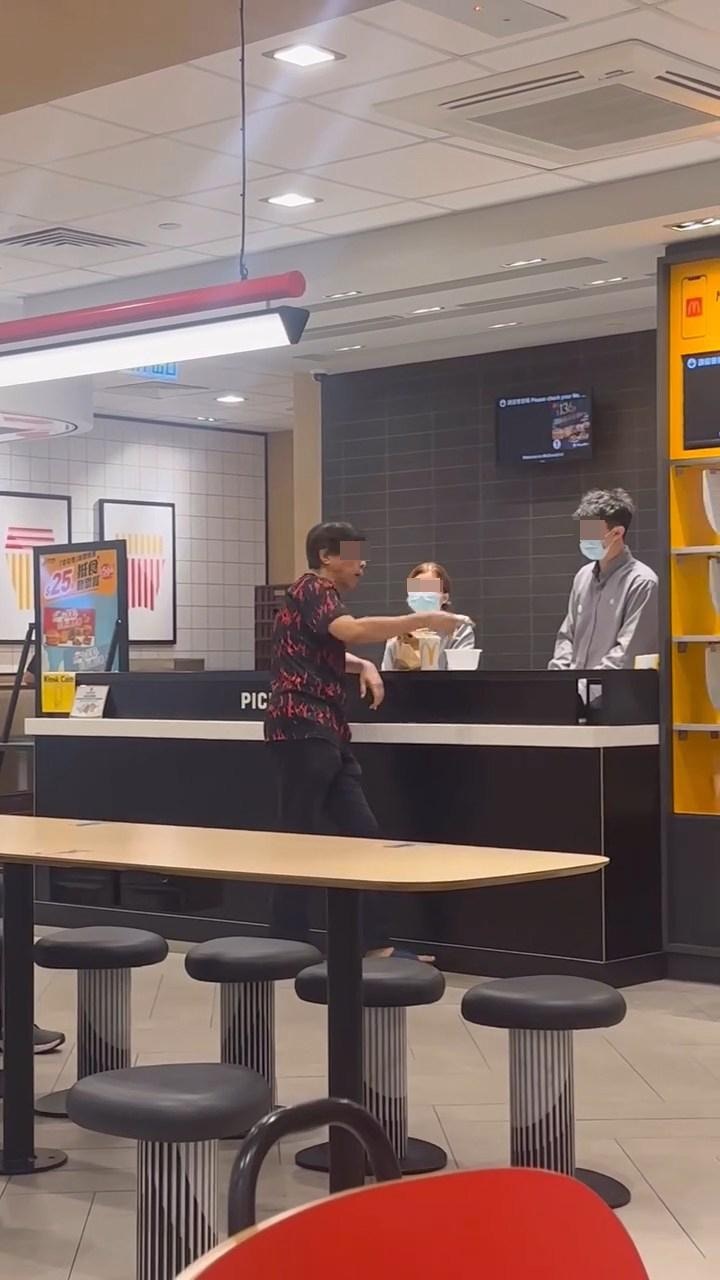 阿叔站在取餐櫃枱位置「發爛渣」，女職員冷靜應對。（Facebook群組「將軍澳主場」）