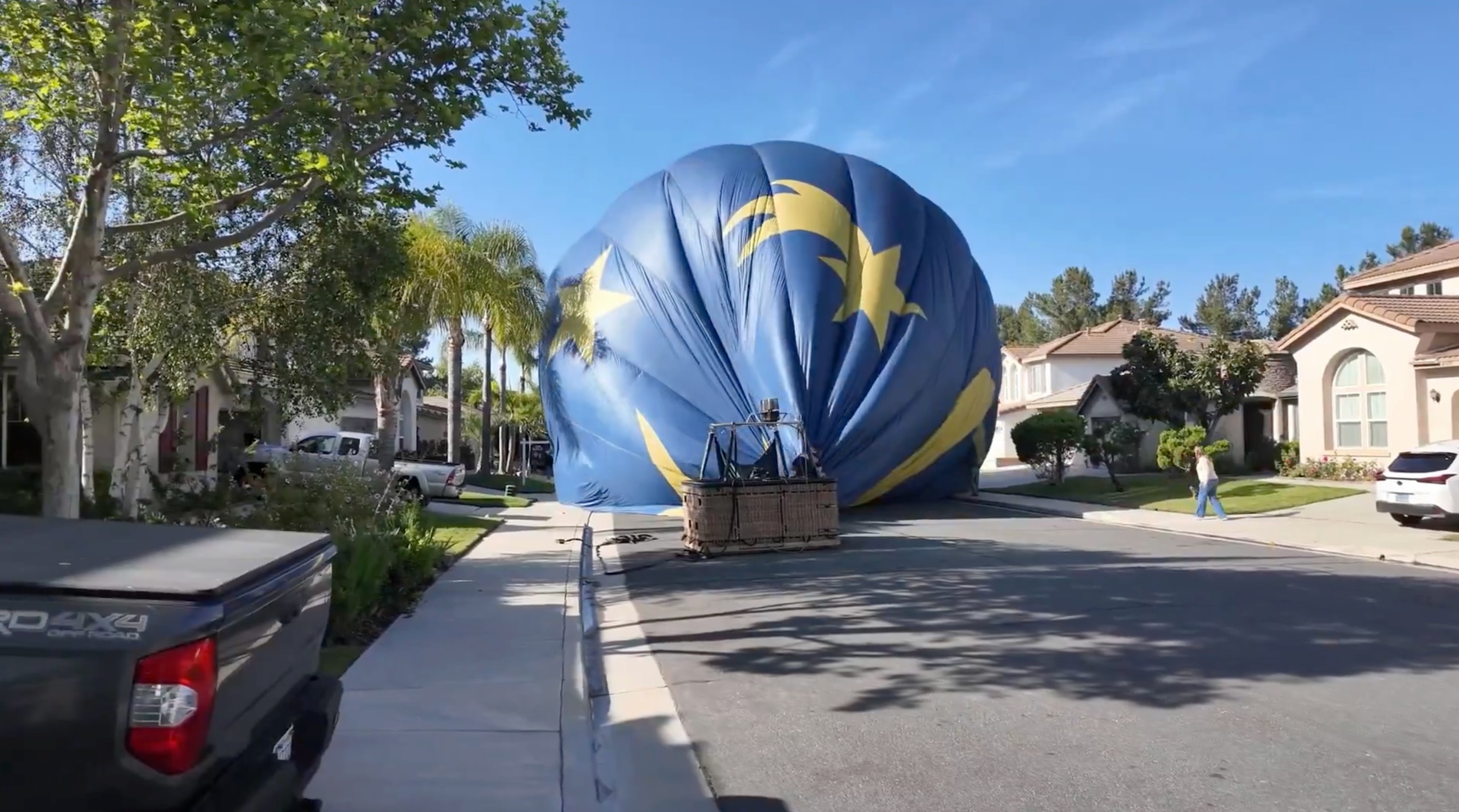 2026年4月18日,一個載有13人的熱氣球於4月18日在美國加州城市蒂梅丘拉(Temecula)一戶民居後院迫降,幸無人受傷。圖為熱氣球重新升空並降落到附近的街道上,準備作進一步拆除。(X@M9USA_) 2026年4月18日,一個載有13人的熱氣球於4月18日在美國加州城市蒂梅丘拉(Temecula)一戶民居後院迫降,幸無人受傷。圖為熱氣球重新升空並降落到附近的街道上,準備作進一步拆除。(X@M9USA_)