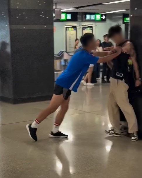 藍衫漢一度出手，將背身紋身男推撞向牆柱。（Threads / jellyfish 影片截圖）