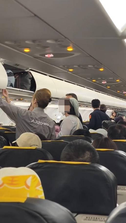 飛機抵達桃園國際機場後，航空警察上機將施暴的女乘客強行帶走。（threads@jeremy_hsueh影片截圖）