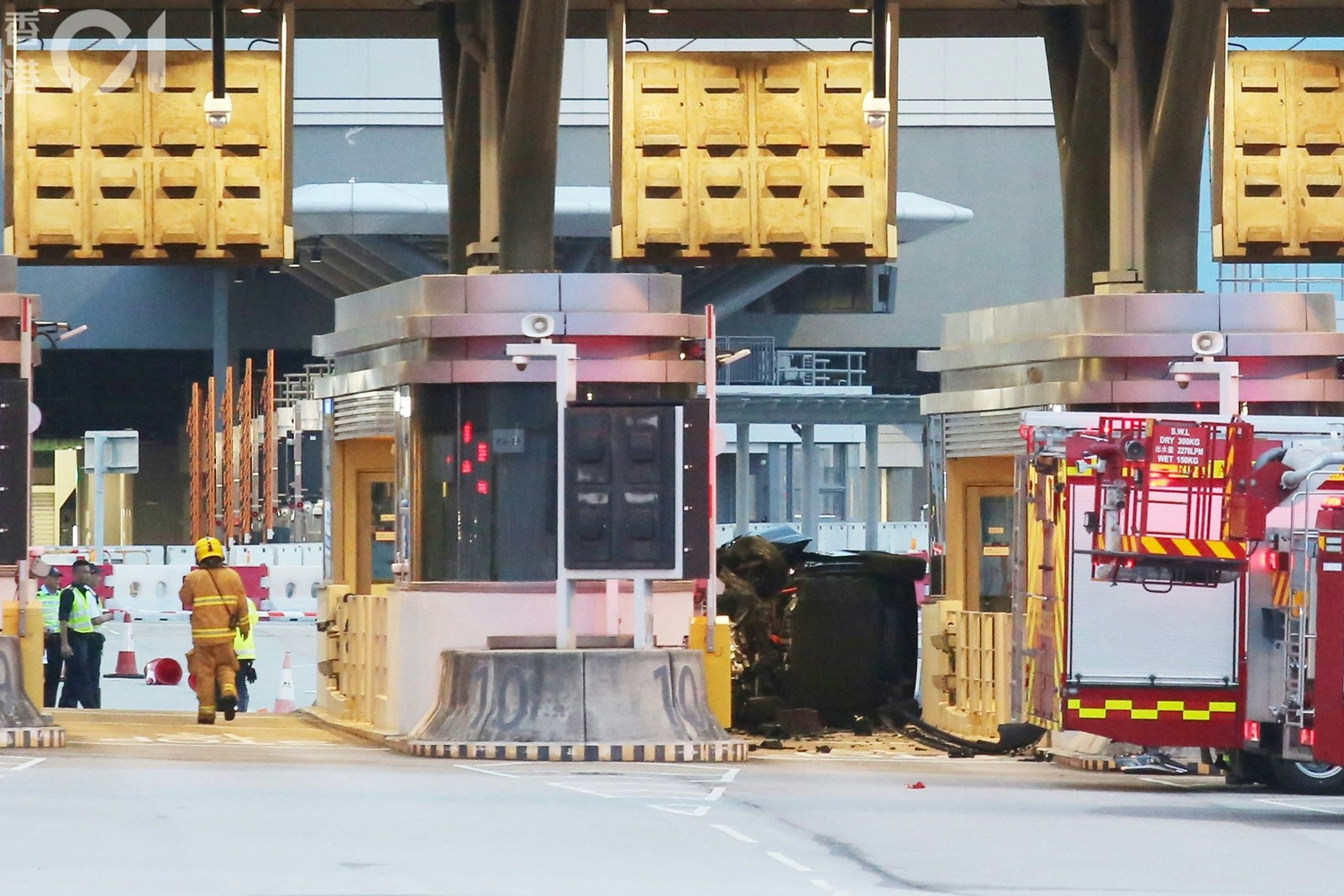 涉事私家車撞向通關廣場檢查亭翻側，車上兩夫婦被困。(陳永武攝)
